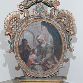 Zdjęcie nr 1: Pole obrazowe w formie stojącego owalu, ujęte profilowaną ramą dekorowaną rocaille&#039;ową falbaną. Po bokach uszaki utworzone z wolut, rocaille&#039;u i kratki regencyjnej, przechodzące w szczyt w formie uproszczonego baldachimu z cokołem zwieńczonym sercem, zdobionego wolutami i ornamentem roślinnym. Pod baldachimem medalion z monogramem Marii w glorii. Pole obrazowe ustawione na cokole o wolutowym kształcie nóżek i fantazyjnie wyciętej dolnej krawędzi, zamkniętym fragmentem gzymsu. W jego polu otwory na drążki. 
Na obrazie Nauczania Marii w centrum ukazana siedząca św. Anna, zwrócona w trzech czwartych w prawo, z pochyloną głową. Lewą ręką obejmuje stojącą przy jej boku Marię, prawą wskazuje na księgę leżącą na jej kolanach. Twarz ma owalną, o małych oczach skierowanych w dół, małym nosie i ustach. Nad głową ma nimb. Ubrana jest w białą suknię spodnią i zieloną suknię wierzchnią oraz jasnobrązowy płaszcz, na głowie ma biały welon. Maria ukazana w półpostaci, zwrócona jest w trzech czwartych w lewo, pochylona, w obu wyciągniętych do przodu rękach trzyma otwartą księgę na kolanach św. Anny. Twarz ma owalną, o małych oczach skierowanych w dół, małym nosie i ustach, okoloną jasnymi włosami, upiętymi z tyłu głowy, wokół niej gloria promienista. Ubrana jest w jasnoczerwoną suknię i niebieski płaszcz. W lewej części obrazu, na drugim planie stoi św. Joachim, zwrócony w trzech czwartych w lewo, z obiema dłońmi opartymi na lasce. Twarz ma owalną, o małych oczach skierowanych w dół, małym nosie i ustach, okoloną siwą brodą. Na głowie ma niebieskie nakrycie, a wokół niej nimb. Ubrany jest w jasnofioletową tunikę i niebieski płaszcz. Postacie ukazane na tle wnętrza z widocznymi arkadami. W prawej części obrazu kolumny zakryte ciemnoniebieską draperią, obszytą frędzlą, z chwostami. 
Na obrazie św. Alojzego w centrum ukazany święty w półpostaci, zwrócony profilem w prawo, pochylony nad stołem. W lewej, uniesionej ręce trzyma krucyfiks i białą tkaninę, prawa leży na stole, w dłoni trzyma dyscyplinę. Twarz ma pełną, o dużych, okrągłych oczach skierowanych w dół, dużym, garbatym nosie, pełnych ustach i wystającej brodzie. Włosy krótkie, brązowe. Ubrany jest w czarną sutannę. Stół nakryty jest czerwoną tkaniną, leży na nim czaszka, lilia i korona otwarta. Święty ukazany na tle nieba, wypełnionego obłokami, na którego tle unoszą się dwie grupy uskrzydlonych główek anielskich.

