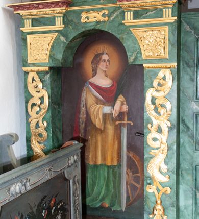 Zdjęcie nr 36: Nastawa architektoniczna, dwukondygnacyjna, pierwsza kondygnacja trójosiowa, druga jednoosiowa, z bramkami, ustawiona na cokole z wyodrębnionymi prostopadłościanami. Ołtarz murowany, w drewnianej obudowie, mensa drewniana. Boki ołtarza dekorowane malowanymi przedstawieniami nawiązującymi do alegorii Eucharystii, na prawym stół pokładny z chlebami pokładnymi, na lewym menora. Antepedium ujęte ramą, w polu trzy owalne pola, w środkowym ukazany Przybytek Świątyni Jerozolimskiej, w prawym ołtarz ofiary całopalnej, w lewym Arka Przymierza. Pola ujęte są malowanymi gałązkami oliwnymi. Oś środkowa pierwszej kondygnacji wydzielona parą kolumn o kapitelach kompozytowych, dźwigających pełne belkowanie, nad polem głównym wyłamane na kształt łuku odcinkowego, z przerwanym architrawem. Na belkowaniu fragmenty przerwanego półkolistego przyczółka z cokołami na figury św. Jadwigi Śląskiej i św. Elżbiety oraz rzeźby klęczących aniołów. Fryz dekorowany stylizowaną małżowiną i uskrzydlonymi główkami anielskimi. W polu środkowym wnęka w formie stojącego prostokąta zamkniętego łukiem odcinkowym, ujęta wąską ramą, flankowana lizenami zdobionymi wicią winnego grona. W polu obraz Wszystkich Świętych adorujących Trójcę Świętą. Na osiach bocznych nisze z konchami zdobionymi stylizowaną małżowiną, w których na wspornikach stoją figury św. Filipa i św. Jakuba Większego. Kondygnacja ujęta uszami utworzonymi z ornamentu małżowinowo-chrząstkowego i uskrzydlonych główek anielskich z czubami. 
Druga kondygnacja ustawiona na cokole, flankowana parą kolumn dźwigających pełne belkowanie, wyłamane na ich osi, oraz fragmenty zdwojonego, przerwanego, trójkątnego przyczółka z cokołami na figury św. Szczepana i św. Wawrzyńca. Fryz dekorowany małżowiną, rautami i uskrzydloną główką anielską. W centralnym punkcie belkowania cokół zakończony gzymsem, dekorowanym uskrzydloną główką anielską, z figurą św. Michała Archanioła. W polu głęboka wnęka w formie kwadratu, zamkniętego z dwóch stron łukami odcinkowymi nadwieszonymi, ujęta profilowaną ramą, z figurą Marki Boskiej Niepokalanie Poczętej, w glorii promienistej. Pole dekorowane małżowiną. 
Bramki umieszczone w przestrzeni dobudowanego do nastawy cokołu, wyodrębnione z niego. Przejścia w formie stojącego prostokąta zamkniętego łukiem półkolistym nadwieszonym, flankowane stylizowanymi pilastrami o trzonach dekorowanych stylizowaną wstęgą z akantem, dźwigającymi imposty zdobione rozetami. Na bramkach, na niskich cokołach małe aedicule z konchami, ujęte parami półkolumienek, dekorowane z trzech stron wstęgą z akantem przechodzącą w rogi obfitości z kampanulami oraz wicią roślinną z anthemionem. W aediculach figury św. Piotra i św. Pawła. Drzwiczki z malowanymi przedstawieniami św. Katarzyny Aleksandryjskiej  i św. Barbary. Struktura polichromowana w sposób imitujący marmoryzację w różnych odcieniach zieleni, kolumny, ornamentyka i profile złocone. 

