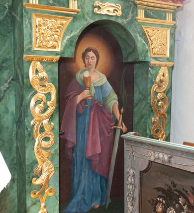 Zdjęcie nr 37: Nastawa architektoniczna, dwukondygnacyjna, pierwsza kondygnacja trójosiowa, druga jednoosiowa, z bramkami, ustawiona na cokole z wyodrębnionymi prostopadłościanami. Ołtarz murowany, w drewnianej obudowie, mensa drewniana. Boki ołtarza dekorowane malowanymi przedstawieniami nawiązującymi do alegorii Eucharystii, na prawym stół pokładny z chlebami pokładnymi, na lewym menora. Antepedium ujęte ramą, w polu trzy owalne pola, w środkowym ukazany Przybytek Świątyni Jerozolimskiej, w prawym ołtarz ofiary całopalnej, w lewym Arka Przymierza. Pola ujęte są malowanymi gałązkami oliwnymi. Oś środkowa pierwszej kondygnacji wydzielona parą kolumn o kapitelach kompozytowych, dźwigających pełne belkowanie, nad polem głównym wyłamane na kształt łuku odcinkowego, z przerwanym architrawem. Na belkowaniu fragmenty przerwanego półkolistego przyczółka z cokołami na figury św. Jadwigi Śląskiej i św. Elżbiety oraz rzeźby klęczących aniołów. Fryz dekorowany stylizowaną małżowiną i uskrzydlonymi główkami anielskimi. W polu środkowym wnęka w formie stojącego prostokąta zamkniętego łukiem odcinkowym, ujęta wąską ramą, flankowana lizenami zdobionymi wicią winnego grona. W polu obraz Wszystkich Świętych adorujących Trójcę Świętą. Na osiach bocznych nisze z konchami zdobionymi stylizowaną małżowiną, w których na wspornikach stoją figury św. Filipa i św. Jakuba Większego. Kondygnacja ujęta uszami utworzonymi z ornamentu małżowinowo-chrząstkowego i uskrzydlonych główek anielskich z czubami. 
Druga kondygnacja ustawiona na cokole, flankowana parą kolumn dźwigających pełne belkowanie, wyłamane na ich osi, oraz fragmenty zdwojonego, przerwanego, trójkątnego przyczółka z cokołami na figury św. Szczepana i św. Wawrzyńca. Fryz dekorowany małżowiną, rautami i uskrzydloną główką anielską. W centralnym punkcie belkowania cokół zakończony gzymsem, dekorowanym uskrzydloną główką anielską, z figurą św. Michała Archanioła. W polu głęboka wnęka w formie kwadratu, zamkniętego z dwóch stron łukami odcinkowymi nadwieszonymi, ujęta profilowaną ramą, z figurą Marki Boskiej Niepokalanie Poczętej, w glorii promienistej. Pole dekorowane małżowiną. 
Bramki umieszczone w przestrzeni dobudowanego do nastawy cokołu, wyodrębnione z niego. Przejścia w formie stojącego prostokąta zamkniętego łukiem półkolistym nadwieszonym, flankowane stylizowanymi pilastrami o trzonach dekorowanych stylizowaną wstęgą z akantem, dźwigającymi imposty zdobione rozetami. Na bramkach, na niskich cokołach małe aedicule z konchami, ujęte parami półkolumienek, dekorowane z trzech stron wstęgą z akantem przechodzącą w rogi obfitości z kampanulami oraz wicią roślinną z anthemionem. W aediculach figury św. Piotra i św. Pawła. Drzwiczki z malowanymi przedstawieniami św. Katarzyny Aleksandryjskiej  i św. Barbary. Struktura polichromowana w sposób imitujący marmoryzację w różnych odcieniach zieleni, kolumny, ornamentyka i profile złocone. 

