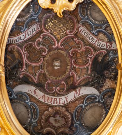 Zdjęcie nr 32: Nastawa architektoniczna, dwukondygnacyjna, pierwsza kondygnacja trójosiowa, druga jednoosiowa, z bramkami, ustawiona na cokole z wyodrębnionymi prostopadłościanami. Ołtarz murowany, w drewnianej obudowie, mensa drewniana. Boki ołtarza dekorowane malowanymi przedstawieniami nawiązującymi do alegorii Eucharystii, na prawym stół pokładny z chlebami pokładnymi, na lewym menora. Antepedium ujęte ramą, w polu trzy owalne pola, w środkowym ukazany Przybytek Świątyni Jerozolimskiej, w prawym ołtarz ofiary całopalnej, w lewym Arka Przymierza. Pola ujęte są malowanymi gałązkami oliwnymi. Oś środkowa pierwszej kondygnacji wydzielona parą kolumn o kapitelach kompozytowych, dźwigających pełne belkowanie, nad polem głównym wyłamane na kształt łuku odcinkowego, z przerwanym architrawem. Na belkowaniu fragmenty przerwanego półkolistego przyczółka z cokołami na figury św. Jadwigi Śląskiej i św. Elżbiety oraz rzeźby klęczących aniołów. Fryz dekorowany stylizowaną małżowiną i uskrzydlonymi główkami anielskimi. W polu środkowym wnęka w formie stojącego prostokąta zamkniętego łukiem odcinkowym, ujęta wąską ramą, flankowana lizenami zdobionymi wicią winnego grona. W polu obraz Wszystkich Świętych adorujących Trójcę Świętą. Na osiach bocznych nisze z konchami zdobionymi stylizowaną małżowiną, w których na wspornikach stoją figury św. Filipa i św. Jakuba Większego. Kondygnacja ujęta uszami utworzonymi z ornamentu małżowinowo-chrząstkowego i uskrzydlonych główek anielskich z czubami. 
Druga kondygnacja ustawiona na cokole, flankowana parą kolumn dźwigających pełne belkowanie, wyłamane na ich osi, oraz fragmenty zdwojonego, przerwanego, trójkątnego przyczółka z cokołami na figury św. Szczepana i św. Wawrzyńca. Fryz dekorowany małżowiną, rautami i uskrzydloną główką anielską. W centralnym punkcie belkowania cokół zakończony gzymsem, dekorowanym uskrzydloną główką anielską, z figurą św. Michała Archanioła. W polu głęboka wnęka w formie kwadratu, zamkniętego z dwóch stron łukami odcinkowymi nadwieszonymi, ujęta profilowaną ramą, z figurą Marki Boskiej Niepokalanie Poczętej, w glorii promienistej. Pole dekorowane małżowiną. 
Bramki umieszczone w przestrzeni dobudowanego do nastawy cokołu, wyodrębnione z niego. Przejścia w formie stojącego prostokąta zamkniętego łukiem półkolistym nadwieszonym, flankowane stylizowanymi pilastrami o trzonach dekorowanych stylizowaną wstęgą z akantem, dźwigającymi imposty zdobione rozetami. Na bramkach, na niskich cokołach małe aedicule z konchami, ujęte parami półkolumienek, dekorowane z trzech stron wstęgą z akantem przechodzącą w rogi obfitości z kampanulami oraz wicią roślinną z anthemionem. W aediculach figury św. Piotra i św. Pawła. Drzwiczki z malowanymi przedstawieniami św. Katarzyny Aleksandryjskiej  i św. Barbary. Struktura polichromowana w sposób imitujący marmoryzację w różnych odcieniach zieleni, kolumny, ornamentyka i profile złocone. 

