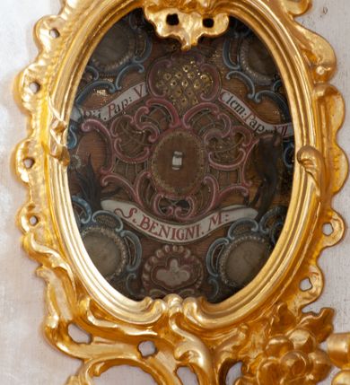 Zdjęcie nr 31: Nastawa architektoniczna, dwukondygnacyjna, pierwsza kondygnacja trójosiowa, druga jednoosiowa, z bramkami, ustawiona na cokole z wyodrębnionymi prostopadłościanami. Ołtarz murowany, w drewnianej obudowie, mensa drewniana. Boki ołtarza dekorowane malowanymi przedstawieniami nawiązującymi do alegorii Eucharystii, na prawym stół pokładny z chlebami pokładnymi, na lewym menora. Antepedium ujęte ramą, w polu trzy owalne pola, w środkowym ukazany Przybytek Świątyni Jerozolimskiej, w prawym ołtarz ofiary całopalnej, w lewym Arka Przymierza. Pola ujęte są malowanymi gałązkami oliwnymi. Oś środkowa pierwszej kondygnacji wydzielona parą kolumn o kapitelach kompozytowych, dźwigających pełne belkowanie, nad polem głównym wyłamane na kształt łuku odcinkowego, z przerwanym architrawem. Na belkowaniu fragmenty przerwanego półkolistego przyczółka z cokołami na figury św. Jadwigi Śląskiej i św. Elżbiety oraz rzeźby klęczących aniołów. Fryz dekorowany stylizowaną małżowiną i uskrzydlonymi główkami anielskimi. W polu środkowym wnęka w formie stojącego prostokąta zamkniętego łukiem odcinkowym, ujęta wąską ramą, flankowana lizenami zdobionymi wicią winnego grona. W polu obraz Wszystkich Świętych adorujących Trójcę Świętą. Na osiach bocznych nisze z konchami zdobionymi stylizowaną małżowiną, w których na wspornikach stoją figury św. Filipa i św. Jakuba Większego. Kondygnacja ujęta uszami utworzonymi z ornamentu małżowinowo-chrząstkowego i uskrzydlonych główek anielskich z czubami. 
Druga kondygnacja ustawiona na cokole, flankowana parą kolumn dźwigających pełne belkowanie, wyłamane na ich osi, oraz fragmenty zdwojonego, przerwanego, trójkątnego przyczółka z cokołami na figury św. Szczepana i św. Wawrzyńca. Fryz dekorowany małżowiną, rautami i uskrzydloną główką anielską. W centralnym punkcie belkowania cokół zakończony gzymsem, dekorowanym uskrzydloną główką anielską, z figurą św. Michała Archanioła. W polu głęboka wnęka w formie kwadratu, zamkniętego z dwóch stron łukami odcinkowymi nadwieszonymi, ujęta profilowaną ramą, z figurą Marki Boskiej Niepokalanie Poczętej, w glorii promienistej. Pole dekorowane małżowiną. 
Bramki umieszczone w przestrzeni dobudowanego do nastawy cokołu, wyodrębnione z niego. Przejścia w formie stojącego prostokąta zamkniętego łukiem półkolistym nadwieszonym, flankowane stylizowanymi pilastrami o trzonach dekorowanych stylizowaną wstęgą z akantem, dźwigającymi imposty zdobione rozetami. Na bramkach, na niskich cokołach małe aedicule z konchami, ujęte parami półkolumienek, dekorowane z trzech stron wstęgą z akantem przechodzącą w rogi obfitości z kampanulami oraz wicią roślinną z anthemionem. W aediculach figury św. Piotra i św. Pawła. Drzwiczki z malowanymi przedstawieniami św. Katarzyny Aleksandryjskiej  i św. Barbary. Struktura polichromowana w sposób imitujący marmoryzację w różnych odcieniach zieleni, kolumny, ornamentyka i profile złocone. 

