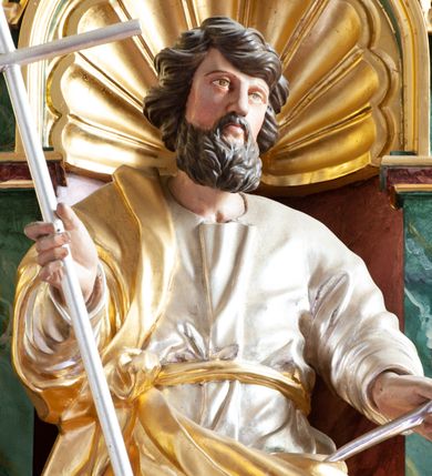 Zdjęcie nr 14: Nastawa architektoniczna, dwukondygnacyjna, pierwsza kondygnacja trójosiowa, druga jednoosiowa, z bramkami, ustawiona na cokole z wyodrębnionymi prostopadłościanami. Ołtarz murowany, w drewnianej obudowie, mensa drewniana. Boki ołtarza dekorowane malowanymi przedstawieniami nawiązującymi do alegorii Eucharystii, na prawym stół pokładny z chlebami pokładnymi, na lewym menora. Antepedium ujęte ramą, w polu trzy owalne pola, w środkowym ukazany Przybytek Świątyni Jerozolimskiej, w prawym ołtarz ofiary całopalnej, w lewym Arka Przymierza. Pola ujęte są malowanymi gałązkami oliwnymi. Oś środkowa pierwszej kondygnacji wydzielona parą kolumn o kapitelach kompozytowych, dźwigających pełne belkowanie, nad polem głównym wyłamane na kształt łuku odcinkowego, z przerwanym architrawem. Na belkowaniu fragmenty przerwanego półkolistego przyczółka z cokołami na figury św. Jadwigi Śląskiej i św. Elżbiety oraz rzeźby klęczących aniołów. Fryz dekorowany stylizowaną małżowiną i uskrzydlonymi główkami anielskimi. W polu środkowym wnęka w formie stojącego prostokąta zamkniętego łukiem odcinkowym, ujęta wąską ramą, flankowana lizenami zdobionymi wicią winnego grona. W polu obraz Wszystkich Świętych adorujących Trójcę Świętą. Na osiach bocznych nisze z konchami zdobionymi stylizowaną małżowiną, w których na wspornikach stoją figury św. Filipa i św. Jakuba Większego. Kondygnacja ujęta uszami utworzonymi z ornamentu małżowinowo-chrząstkowego i uskrzydlonych główek anielskich z czubami. 
Druga kondygnacja ustawiona na cokole, flankowana parą kolumn dźwigających pełne belkowanie, wyłamane na ich osi, oraz fragmenty zdwojonego, przerwanego, trójkątnego przyczółka z cokołami na figury św. Szczepana i św. Wawrzyńca. Fryz dekorowany małżowiną, rautami i uskrzydloną główką anielską. W centralnym punkcie belkowania cokół zakończony gzymsem, dekorowanym uskrzydloną główką anielską, z figurą św. Michała Archanioła. W polu głęboka wnęka w formie kwadratu, zamkniętego z dwóch stron łukami odcinkowymi nadwieszonymi, ujęta profilowaną ramą, z figurą Marki Boskiej Niepokalanie Poczętej, w glorii promienistej. Pole dekorowane małżowiną. 
Bramki umieszczone w przestrzeni dobudowanego do nastawy cokołu, wyodrębnione z niego. Przejścia w formie stojącego prostokąta zamkniętego łukiem półkolistym nadwieszonym, flankowane stylizowanymi pilastrami o trzonach dekorowanych stylizowaną wstęgą z akantem, dźwigającymi imposty zdobione rozetami. Na bramkach, na niskich cokołach małe aedicule z konchami, ujęte parami półkolumienek, dekorowane z trzech stron wstęgą z akantem przechodzącą w rogi obfitości z kampanulami oraz wicią roślinną z anthemionem. W aediculach figury św. Piotra i św. Pawła. Drzwiczki z malowanymi przedstawieniami św. Katarzyny Aleksandryjskiej  i św. Barbary. Struktura polichromowana w sposób imitujący marmoryzację w różnych odcieniach zieleni, kolumny, ornamentyka i profile złocone. 

