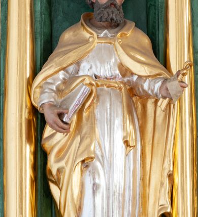Zdjęcie nr 16: Nastawa architektoniczna, dwukondygnacyjna, pierwsza kondygnacja trójosiowa, druga jednoosiowa, z bramkami, ustawiona na cokole z wyodrębnionymi prostopadłościanami. Ołtarz murowany, w drewnianej obudowie, mensa drewniana. Boki ołtarza dekorowane malowanymi przedstawieniami nawiązującymi do alegorii Eucharystii, na prawym stół pokładny z chlebami pokładnymi, na lewym menora. Antepedium ujęte ramą, w polu trzy owalne pola, w środkowym ukazany Przybytek Świątyni Jerozolimskiej, w prawym ołtarz ofiary całopalnej, w lewym Arka Przymierza. Pola ujęte są malowanymi gałązkami oliwnymi. Oś środkowa pierwszej kondygnacji wydzielona parą kolumn o kapitelach kompozytowych, dźwigających pełne belkowanie, nad polem głównym wyłamane na kształt łuku odcinkowego, z przerwanym architrawem. Na belkowaniu fragmenty przerwanego półkolistego przyczółka z cokołami na figury św. Jadwigi Śląskiej i św. Elżbiety oraz rzeźby klęczących aniołów. Fryz dekorowany stylizowaną małżowiną i uskrzydlonymi główkami anielskimi. W polu środkowym wnęka w formie stojącego prostokąta zamkniętego łukiem odcinkowym, ujęta wąską ramą, flankowana lizenami zdobionymi wicią winnego grona. W polu obraz Wszystkich Świętych adorujących Trójcę Świętą. Na osiach bocznych nisze z konchami zdobionymi stylizowaną małżowiną, w których na wspornikach stoją figury św. Filipa i św. Jakuba Większego. Kondygnacja ujęta uszami utworzonymi z ornamentu małżowinowo-chrząstkowego i uskrzydlonych główek anielskich z czubami. 
Druga kondygnacja ustawiona na cokole, flankowana parą kolumn dźwigających pełne belkowanie, wyłamane na ich osi, oraz fragmenty zdwojonego, przerwanego, trójkątnego przyczółka z cokołami na figury św. Szczepana i św. Wawrzyńca. Fryz dekorowany małżowiną, rautami i uskrzydloną główką anielską. W centralnym punkcie belkowania cokół zakończony gzymsem, dekorowanym uskrzydloną główką anielską, z figurą św. Michała Archanioła. W polu głęboka wnęka w formie kwadratu, zamkniętego z dwóch stron łukami odcinkowymi nadwieszonymi, ujęta profilowaną ramą, z figurą Marki Boskiej Niepokalanie Poczętej, w glorii promienistej. Pole dekorowane małżowiną. 
Bramki umieszczone w przestrzeni dobudowanego do nastawy cokołu, wyodrębnione z niego. Przejścia w formie stojącego prostokąta zamkniętego łukiem półkolistym nadwieszonym, flankowane stylizowanymi pilastrami o trzonach dekorowanych stylizowaną wstęgą z akantem, dźwigającymi imposty zdobione rozetami. Na bramkach, na niskich cokołach małe aedicule z konchami, ujęte parami półkolumienek, dekorowane z trzech stron wstęgą z akantem przechodzącą w rogi obfitości z kampanulami oraz wicią roślinną z anthemionem. W aediculach figury św. Piotra i św. Pawła. Drzwiczki z malowanymi przedstawieniami św. Katarzyny Aleksandryjskiej  i św. Barbary. Struktura polichromowana w sposób imitujący marmoryzację w różnych odcieniach zieleni, kolumny, ornamentyka i profile złocone. 

