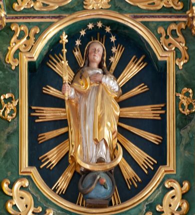 Zdjęcie nr 42: Nastawa architektoniczna, dwukondygnacyjna, pierwsza kondygnacja trójosiowa, druga jednoosiowa, z bramkami, ustawiona na cokole z wyodrębnionymi prostopadłościanami. Ołtarz murowany, w drewnianej obudowie, mensa drewniana. Boki ołtarza dekorowane malowanymi przedstawieniami nawiązującymi do alegorii Eucharystii, na prawym stół pokładny z chlebami pokładnymi, na lewym menora. Antepedium ujęte ramą, w polu trzy owalne pola, w środkowym ukazany Przybytek Świątyni Jerozolimskiej, w prawym ołtarz ofiary całopalnej, w lewym Arka Przymierza. Pola ujęte są malowanymi gałązkami oliwnymi. Oś środkowa pierwszej kondygnacji wydzielona parą kolumn o kapitelach kompozytowych, dźwigających pełne belkowanie, nad polem głównym wyłamane na kształt łuku odcinkowego, z przerwanym architrawem. Na belkowaniu fragmenty przerwanego półkolistego przyczółka z cokołami na figury św. Jadwigi Śląskiej i św. Elżbiety oraz rzeźby klęczących aniołów. Fryz dekorowany stylizowaną małżowiną i uskrzydlonymi główkami anielskimi. W polu środkowym wnęka w formie stojącego prostokąta zamkniętego łukiem odcinkowym, ujęta wąską ramą, flankowana lizenami zdobionymi wicią winnego grona. W polu obraz Wszystkich Świętych adorujących Trójcę Świętą. Na osiach bocznych nisze z konchami zdobionymi stylizowaną małżowiną, w których na wspornikach stoją figury św. Filipa i św. Jakuba Większego. Kondygnacja ujęta uszami utworzonymi z ornamentu małżowinowo-chrząstkowego i uskrzydlonych główek anielskich z czubami. 
Druga kondygnacja ustawiona na cokole, flankowana parą kolumn dźwigających pełne belkowanie, wyłamane na ich osi, oraz fragmenty zdwojonego, przerwanego, trójkątnego przyczółka z cokołami na figury św. Szczepana i św. Wawrzyńca. Fryz dekorowany małżowiną, rautami i uskrzydloną główką anielską. W centralnym punkcie belkowania cokół zakończony gzymsem, dekorowanym uskrzydloną główką anielską, z figurą św. Michała Archanioła. W polu głęboka wnęka w formie kwadratu, zamkniętego z dwóch stron łukami odcinkowymi nadwieszonymi, ujęta profilowaną ramą, z figurą Marki Boskiej Niepokalanie Poczętej, w glorii promienistej. Pole dekorowane małżowiną. 
Bramki umieszczone w przestrzeni dobudowanego do nastawy cokołu, wyodrębnione z niego. Przejścia w formie stojącego prostokąta zamkniętego łukiem półkolistym nadwieszonym, flankowane stylizowanymi pilastrami o trzonach dekorowanych stylizowaną wstęgą z akantem, dźwigającymi imposty zdobione rozetami. Na bramkach, na niskich cokołach małe aedicule z konchami, ujęte parami półkolumienek, dekorowane z trzech stron wstęgą z akantem przechodzącą w rogi obfitości z kampanulami oraz wicią roślinną z anthemionem. W aediculach figury św. Piotra i św. Pawła. Drzwiczki z malowanymi przedstawieniami św. Katarzyny Aleksandryjskiej  i św. Barbary. Struktura polichromowana w sposób imitujący marmoryzację w różnych odcieniach zieleni, kolumny, ornamentyka i profile złocone. 

