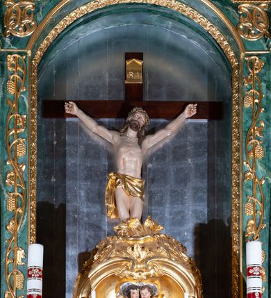 Zdjęcie nr 24: Nastawa architektoniczna, dwukondygnacyjna, pierwsza kondygnacja trójosiowa, druga jednoosiowa, z bramkami, ustawiona na cokole z wyodrębnionymi prostopadłościanami. Ołtarz murowany, w drewnianej obudowie, mensa drewniana. Boki ołtarza dekorowane malowanymi przedstawieniami nawiązującymi do alegorii Eucharystii, na prawym stół pokładny z chlebami pokładnymi, na lewym menora. Antepedium ujęte ramą, w polu trzy owalne pola, w środkowym ukazany Przybytek Świątyni Jerozolimskiej, w prawym ołtarz ofiary całopalnej, w lewym Arka Przymierza. Pola ujęte są malowanymi gałązkami oliwnymi. Oś środkowa pierwszej kondygnacji wydzielona parą kolumn o kapitelach kompozytowych, dźwigających pełne belkowanie, nad polem głównym wyłamane na kształt łuku odcinkowego, z przerwanym architrawem. Na belkowaniu fragmenty przerwanego półkolistego przyczółka z cokołami na figury św. Jadwigi Śląskiej i św. Elżbiety oraz rzeźby klęczących aniołów. Fryz dekorowany stylizowaną małżowiną i uskrzydlonymi główkami anielskimi. W polu środkowym wnęka w formie stojącego prostokąta zamkniętego łukiem odcinkowym, ujęta wąską ramą, flankowana lizenami zdobionymi wicią winnego grona. W polu obraz Wszystkich Świętych adorujących Trójcę Świętą. Na osiach bocznych nisze z konchami zdobionymi stylizowaną małżowiną, w których na wspornikach stoją figury św. Filipa i św. Jakuba Większego. Kondygnacja ujęta uszami utworzonymi z ornamentu małżowinowo-chrząstkowego i uskrzydlonych główek anielskich z czubami. 
Druga kondygnacja ustawiona na cokole, flankowana parą kolumn dźwigających pełne belkowanie, wyłamane na ich osi, oraz fragmenty zdwojonego, przerwanego, trójkątnego przyczółka z cokołami na figury św. Szczepana i św. Wawrzyńca. Fryz dekorowany małżowiną, rautami i uskrzydloną główką anielską. W centralnym punkcie belkowania cokół zakończony gzymsem, dekorowanym uskrzydloną główką anielską, z figurą św. Michała Archanioła. W polu głęboka wnęka w formie kwadratu, zamkniętego z dwóch stron łukami odcinkowymi nadwieszonymi, ujęta profilowaną ramą, z figurą Marki Boskiej Niepokalanie Poczętej, w glorii promienistej. Pole dekorowane małżowiną. 
Bramki umieszczone w przestrzeni dobudowanego do nastawy cokołu, wyodrębnione z niego. Przejścia w formie stojącego prostokąta zamkniętego łukiem półkolistym nadwieszonym, flankowane stylizowanymi pilastrami o trzonach dekorowanych stylizowaną wstęgą z akantem, dźwigającymi imposty zdobione rozetami. Na bramkach, na niskich cokołach małe aedicule z konchami, ujęte parami półkolumienek, dekorowane z trzech stron wstęgą z akantem przechodzącą w rogi obfitości z kampanulami oraz wicią roślinną z anthemionem. W aediculach figury św. Piotra i św. Pawła. Drzwiczki z malowanymi przedstawieniami św. Katarzyny Aleksandryjskiej  i św. Barbary. Struktura polichromowana w sposób imitujący marmoryzację w różnych odcieniach zieleni, kolumny, ornamentyka i profile złocone. 

