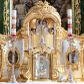Zdjęcie nr 1: Tabernakulum w formie prostopadłościennej szafki na cokole, o wypukłej ścianie frontowej, ujętej spływami wolutowymi, podtrzymującymi wyłamany gzyms. Drzwiczki w kształcie stojącego prostokąta zamkniętego łukiem półkolistym nadwieszonym z uskokiem, ujęte profilowana ramą z przedstawieniem kielicha z hostią w polu. Na tabernakulum cokół. Szafka wkomponowana w trójosiowy tron wystawienia. Oś środkowa w formie niszy, flankowanej spływami wolutowymi, dekorowanej rocaille'm i uskrzydlonymi główkami anielskimi. Po bokach niszy, na osiach bocznych pola o wklęsłych bokach dekorowanych zwisami kwiatowymi, z umieszczonymi pośrodku owalnymi pojemnikami na relikwie ujętymi rocaille'm. Wnętrze pojemników z ornamentalną dekoracją papierową i banderolami oraz relikwiami. W prawym pojemniku napisy: „Innoc(enti) Pap(ae) IX.”, „Gregor(ii) Pap(ae) VII.”, „S(anctae) AUREAE M(artyris)”, „Clement(i) Pap(ae) XI.”, „Bened(icti) Pap(ae) XI.”; w lewym: „Pii. Pap(ae) V.”, „Clem(enti) Pap(ae) XII”, „S(ancti) Benigni(s) M(artyris)”, „Innoc(enti) Pap(ae) XIII.”, „Bened(icti) Pap(ae) XIII.”; „ST[...] VM.”

