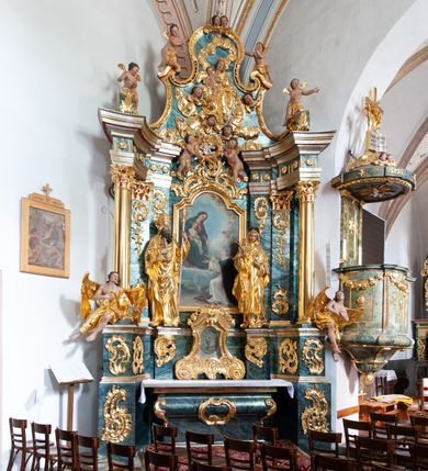 Zdjęcie nr 29: Nastawa architektoniczna, jednoosiowa, jednokondygnacyjna ze zwieńczeniem, ustawiona na dwustrefowym cokole z wyodrębnionymi prostopadłościanami, ustawionymi pod kątem. Ołtarz sarkofagowy, wklęsło-wypukły, dekorowany w narożach ornamentem roślinnym, w polu zaś rocaille'owym kartuszem. Mensa szersza, drewniana. Nastawa na planie półowalu, ujęta dwiema parami pilastrów i stojącą na ich tle parą kolumn o kapitelach kompozytowych. Podpory dźwigają pełne belkowanie, wyłamane półkoliście na ich osi, przerwane nad polem środkowym. Fryz dekorowany rozetami, cokoły rocaille'm, a trzony pilastrów rocaille'm i zwisami roślinnymi. W polu środkowym wnęka w formie stojącego prostokąta zamkniętego łukiem odcinkowym nadwieszonym z uskokiem, ujęta profilowaną ramą, zwieńczoną rocaille'owym szczytem, z aniołkami podtrzymującymi kartusz z monogramem Marii, w polu obraz Matki Boskiej Różańcowej ze św. Dominikiem. Wnękę flankują figury św. Piusa V i św. Katarzyny Sieneńskiej ustawione na rocaille'owych wspornikach. Na zewnętrzych krawędziach cokołu siedzą figury aniołów. Zwieńczenie o fantazyjnej, wklęsło-wypukłej formie, z uszakami i puttami, ujęte wolutami spływającymi na belkowanie, na których siedzą putta; obwiedzione rocaille'm, zakończone dwiema uskrzydlonymi główkami anielskimi. W polu płaskorzeźbione przedstawienie Matki Boskiej z Dzieciątkiem tronującej pośród obłoków i uskrzydlonych główek anielskich. Struktura polichromowana na sposób imitujący marmoryzację w różnych odcieniach zieleni, kolumny, ornamentyka i profile złocone, niektóre profile srebrzone. 