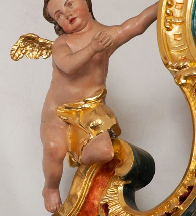 Zdjęcie nr 17: Nastawa architektoniczna, jednoosiowa, jednokondygnacyjna ze zwieńczeniem, ustawiona na dwustrefowym cokole z wyodrębnionymi prostopadłościanami, ustawionymi pod kątem. Ołtarz sarkofagowy, wklęsło-wypukły, dekorowany w narożach ornamentem roślinnym, w polu zaś rocaille'owym kartuszem. Mensa szersza, drewniana. Nastawa na planie półowalu, ujęta dwiema parami pilastrów i stojącą na ich tle parą kolumn o kapitelach kompozytowych. Podpory dźwigają pełne belkowanie, wyłamane półkoliście na ich osi, przerwane nad polem środkowym. Fryz dekorowany rozetami, cokoły rocaille'm, a trzony pilastrów rocaille'm i zwisami roślinnymi. W polu środkowym wnęka w formie stojącego prostokąta zamkniętego łukiem odcinkowym nadwieszonym z uskokiem, ujęta profilowaną ramą, zwieńczoną rocaille'owym szczytem, z aniołkami podtrzymującymi kartusz z monogramem Marii, w polu obraz Matki Boskiej Różańcowej ze św. Dominikiem. Wnękę flankują figury św. Piusa V i św. Katarzyny Sieneńskiej ustawione na rocaille'owych wspornikach. Na zewnętrzych krawędziach cokołu siedzą figury aniołów. Zwieńczenie o fantazyjnej, wklęsło-wypukłej formie, z uszakami i puttami, ujęte wolutami spływającymi na belkowanie, na których siedzą putta; obwiedzione rocaille'm, zakończone dwiema uskrzydlonymi główkami anielskimi. W polu płaskorzeźbione przedstawienie Matki Boskiej z Dzieciątkiem tronującej pośród obłoków i uskrzydlonych główek anielskich. Struktura polichromowana na sposób imitujący marmoryzację w różnych odcieniach zieleni, kolumny, ornamentyka i profile złocone, niektóre profile srebrzone. 