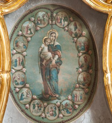 Zdjęcie nr 27: Nastawa architektoniczna, jednoosiowa, jednokondygnacyjna ze zwieńczeniem, ustawiona na dwustrefowym cokole z wyodrębnionymi prostopadłościanami, ustawionymi pod kątem. Ołtarz sarkofagowy, wklęsło-wypukły, dekorowany w narożach ornamentem roślinnym, w polu zaś rocaille'owym kartuszem. Mensa szersza, drewniana. Nastawa na planie półowalu, ujęta dwiema parami pilastrów i stojącą na ich tle parą kolumn o kapitelach kompozytowych. Podpory dźwigają pełne belkowanie, wyłamane półkoliście na ich osi, przerwane nad polem środkowym. Fryz dekorowany rozetami, cokoły rocaille'm, a trzony pilastrów rocaille'm i zwisami roślinnymi. W polu środkowym wnęka w formie stojącego prostokąta zamkniętego łukiem odcinkowym nadwieszonym z uskokiem, ujęta profilowaną ramą, zwieńczoną rocaille'owym szczytem, z aniołkami podtrzymującymi kartusz z monogramem Marii, w polu obraz Matki Boskiej Różańcowej ze św. Dominikiem. Wnękę flankują figury św. Piusa V i św. Katarzyny Sieneńskiej ustawione na rocaille'owych wspornikach. Na zewnętrzych krawędziach cokołu siedzą figury aniołów. Zwieńczenie o fantazyjnej, wklęsło-wypukłej formie, z uszakami i puttami, ujęte wolutami spływającymi na belkowanie, na których siedzą putta; obwiedzione rocaille'm, zakończone dwiema uskrzydlonymi główkami anielskimi. W polu płaskorzeźbione przedstawienie Matki Boskiej z Dzieciątkiem tronującej pośród obłoków i uskrzydlonych główek anielskich. Struktura polichromowana na sposób imitujący marmoryzację w różnych odcieniach zieleni, kolumny, ornamentyka i profile złocone, niektóre profile srebrzone. 