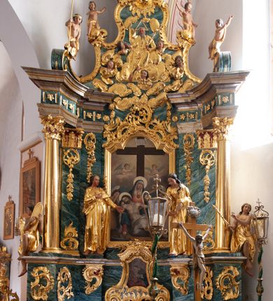 Zdjęcie nr 1: Nastawa architektoniczna, jednoosiowa, jednokondygnacyjna ze zwieńczeniem, ustawiona na dwustrefowym cokole z wyodrębnionymi prostopadłościanami, ustawionymi pod kątem. Ołtarz sarkofagowy, wklęsło-wypukły, dekorowany w narożach ornamentem roślinnym, w polu zaś rocaille'owym kartuszem. Mensa szersza, drewniana. Nastawa na planie półowalu, ujęta dwiema parami pilastrów i stojącą na ich tle parą kolumn o kapitelach kompozytowych. Podpory dźwigają pełne belkowanie, wyłamane półkoliście na ich osi, przerwane nad polem środkowym. Fryz dekorowany rozetami, cokoły rocaille'm, a trzony pilastrów rocaille'm i zwisami roślinnymi. W polu środkowym wnęka w formie stojącego prostokąta zamkniętego łukiem odcinkowym nadwieszonym z uskokiem, ujęta profilowaną ramą, zwieńczoną rocaille'owym szczytem, w polu obraz zdjęcia z krzyża. Wnękę flankują figury św. Jana Ewangelisty i św. Marii Magdaleny ustawione na rocaille'owych wspornikach. Na zewnętrzych krawędziach cokołu siedzą figury aniołów z arma Christi. Zwieńczenie o fantazyjnej, wklęsło-wypukłej formie, z uszakami i puttami, ujęte wolutami spływającymi na belkowanie, na których siedzą putta; obwiedzione rocaille'm, zakończone dwiema uskrzydlonymi główkami anielskimi. W polu płaskorzeźbione przedstawienie Boga Ojca tronującego pośród obłoków i uskrzydlonych główek anielskich. Struktura polichromowana na sposób imitujący marmoryzacje w różnych odcieniach zieleni, kolumny, ornamentyka i profile złocone, niektóre profile srebrzone. 