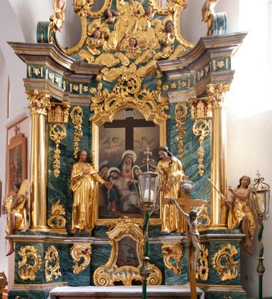 Zdjęcie nr 23: Nastawa architektoniczna, jednoosiowa, jednokondygnacyjna ze zwieńczeniem, ustawiona na dwustrefowym cokole z wyodrębnionymi prostopadłościanami, ustawionymi pod kątem. Ołtarz sarkofagowy, wklęsło-wypukły, dekorowany w narożach ornamentem roślinnym, w polu zaś rocaille'owym kartuszem. Mensa szersza, drewniana. Nastawa na planie półowalu, ujęta dwiema parami pilastrów i stojącą na ich tle parą kolumn o kapitelach kompozytowych. Podpory dźwigają pełne belkowanie, wyłamane półkoliście na ich osi, przerwane nad polem środkowym. Fryz dekorowany rozetami, cokoły rocaille'm, a trzony pilastrów rocaille'm i zwisami roślinnymi. W polu środkowym wnęka w formie stojącego prostokąta zamkniętego łukiem odcinkowym nadwieszonym z uskokiem, ujęta profilowaną ramą, zwieńczoną rocaille'owym szczytem, w polu obraz zdjęcia z krzyża. Wnękę flankują figury św. Jana Ewangelisty i św. Marii Magdaleny ustawione na rocaille'owych wspornikach. Na zewnętrzych krawędziach cokołu siedzą figury aniołów z arma Christi. Zwieńczenie o fantazyjnej, wklęsło-wypukłej formie, z uszakami i puttami, ujęte wolutami spływającymi na belkowanie, na których siedzą putta; obwiedzione rocaille'm, zakończone dwiema uskrzydlonymi główkami anielskimi. W polu płaskorzeźbione przedstawienie Boga Ojca tronującego pośród obłoków i uskrzydlonych główek anielskich. Struktura polichromowana na sposób imitujący marmoryzacje w różnych odcieniach zieleni, kolumny, ornamentyka i profile złocone, niektóre profile srebrzone. 