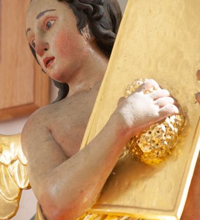 Zdjęcie nr 16: Nastawa architektoniczna, jednoosiowa, jednokondygnacyjna ze zwieńczeniem, ustawiona na dwustrefowym cokole z wyodrębnionymi prostopadłościanami, ustawionymi pod kątem. Ołtarz sarkofagowy, wklęsło-wypukły, dekorowany w narożach ornamentem roślinnym, w polu zaś rocaille'owym kartuszem. Mensa szersza, drewniana. Nastawa na planie półowalu, ujęta dwiema parami pilastrów i stojącą na ich tle parą kolumn o kapitelach kompozytowych. Podpory dźwigają pełne belkowanie, wyłamane półkoliście na ich osi, przerwane nad polem środkowym. Fryz dekorowany rozetami, cokoły rocaille'm, a trzony pilastrów rocaille'm i zwisami roślinnymi. W polu środkowym wnęka w formie stojącego prostokąta zamkniętego łukiem odcinkowym nadwieszonym z uskokiem, ujęta profilowaną ramą, zwieńczoną rocaille'owym szczytem, w polu obraz zdjęcia z krzyża. Wnękę flankują figury św. Jana Ewangelisty i św. Marii Magdaleny ustawione na rocaille'owych wspornikach. Na zewnętrzych krawędziach cokołu siedzą figury aniołów z arma Christi. Zwieńczenie o fantazyjnej, wklęsło-wypukłej formie, z uszakami i puttami, ujęte wolutami spływającymi na belkowanie, na których siedzą putta; obwiedzione rocaille'm, zakończone dwiema uskrzydlonymi główkami anielskimi. W polu płaskorzeźbione przedstawienie Boga Ojca tronującego pośród obłoków i uskrzydlonych główek anielskich. Struktura polichromowana na sposób imitujący marmoryzacje w różnych odcieniach zieleni, kolumny, ornamentyka i profile złocone, niektóre profile srebrzone. 