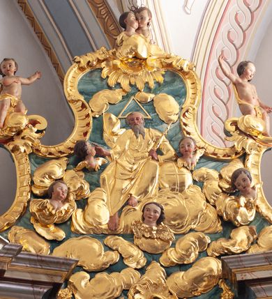 Zdjęcie nr 27: Nastawa architektoniczna, jednoosiowa, jednokondygnacyjna ze zwieńczeniem, ustawiona na dwustrefowym cokole z wyodrębnionymi prostopadłościanami, ustawionymi pod kątem. Ołtarz sarkofagowy, wklęsło-wypukły, dekorowany w narożach ornamentem roślinnym, w polu zaś rocaille'owym kartuszem. Mensa szersza, drewniana. Nastawa na planie półowalu, ujęta dwiema parami pilastrów i stojącą na ich tle parą kolumn o kapitelach kompozytowych. Podpory dźwigają pełne belkowanie, wyłamane półkoliście na ich osi, przerwane nad polem środkowym. Fryz dekorowany rozetami, cokoły rocaille'm, a trzony pilastrów rocaille'm i zwisami roślinnymi. W polu środkowym wnęka w formie stojącego prostokąta zamkniętego łukiem odcinkowym nadwieszonym z uskokiem, ujęta profilowaną ramą, zwieńczoną rocaille'owym szczytem, w polu obraz zdjęcia z krzyża. Wnękę flankują figury św. Jana Ewangelisty i św. Marii Magdaleny ustawione na rocaille'owych wspornikach. Na zewnętrzych krawędziach cokołu siedzą figury aniołów z arma Christi. Zwieńczenie o fantazyjnej, wklęsło-wypukłej formie, z uszakami i puttami, ujęte wolutami spływającymi na belkowanie, na których siedzą putta; obwiedzione rocaille'm, zakończone dwiema uskrzydlonymi główkami anielskimi. W polu płaskorzeźbione przedstawienie Boga Ojca tronującego pośród obłoków i uskrzydlonych główek anielskich. Struktura polichromowana na sposób imitujący marmoryzacje w różnych odcieniach zieleni, kolumny, ornamentyka i profile złocone, niektóre profile srebrzone. 