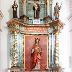 Zdjęcie nr 1: Nastawa architektoniczna, jednoosiowa, dwukondygnacyjna ze zwieńczeniem, ustawiona na dwustrefowym cokole z wyłamanymi pod kątem prostopadłościanami. Ołtarz sarkofagowy, wklęsło-wypukły, na wysokim cokole, dekorowany w narożach ornamentem roślinnym i rocaille&#039;owym kartuszem w polu. Mensa szersza od ołtarza, drewniana. Nastawa ujęta parą kolumn o skręconych trzonach zdobionych wicią roślinną, podtrzymujących pełne belkowanie, wyłamane na ich osi pod kątem. Fryz i cokół na linii kolumn dekorowany płycinami z ornamentem roślinnym, na belkowaniu ustawione figury św. Teresy i św. Józefa. W środkowej części fryzu napis „O najsladsie Srdce môjho Ježiša / učíň, aby som Ta vždy viac a viac milovah”. Całe pole główne wypełnia wnęka ujęta ramą dekorowaną ornamentem roślinnym, z tłem złożonym z kratki i krzyży. Na jej tle, na cokole ustawiona figura Najświętszego Serca Jezusa. Druga kondygnacja węższa, ustawiona na cokole z wyłamanymi pod kątem prostopadłościanami; ujęta parą kolumn podtrzymującą pełne belkowanie, wyłamane na ich osi pod kątem, na nim dwie figurki aniołów. W polu figura św. Antoniego Padewskiego ustawiona na cokole. Zwieńczenie w formie leżącego prostokąta zamkniętego gzymsem przyjmującym kształt łuku półkolistego, dekorowanego ornamentem roślinnym, zwieńczonego krzyżem. W polu medalion z monogramem IHS w glorii promienistej, na wypukłym, półokrągłym cokole. Struktura polichromowana na sposób imitujący marmoryzację w kolorze zielono-białym, z czerwonymi detalami, kolumny, profile oraz ornamentyka złocone i srebrzone.  
