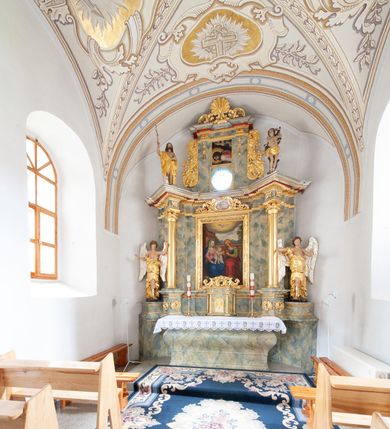 Zdjęcie nr 9: Nastawa architektoniczna, jednoosiowa, jednokondygnacyjna ze zwieńczeniem, ustawiona na dwustrefowym, szerszym cokole, z wyodrębnionymi dwiema parami prostopadłościanów, zwróconymi pod kątem. Ołtarz drewniany, sarkofagowy, wklęsło-wypukły, ustawiony na cokole. Mensa drewniana. Na ołtarzu tabernakulum w formie drewnianej skrzynki, ustawionej na cokole, flankowanej dwiema parami kolumienek, podtrzymujących belkowanie. Drzwiczki w kształcie stojącego prostokąta zamkniętego łukiem półkolistym z przedstawieniem kielicha z hostią w glorii. Całość zwieńczona szczytem utworzonym z rocaille'u i akantu. Nastawa ujęta parą kolumn podtrzymujących pełne belkowanie, z silnie wysuniętym gzymsem, wyłamane pod kątem na ich osi. W partii fryzu kartusz ujęty ornamentem roślinnym z monogramem św. Anny. Na belkowaniu ustawione figury św. Jana Chrzciciela i św. Sebastiana. W polu środkowym wnęka w formie stojącego prostokąta w wąskiej ramie, w niej obraz św. Anny Samotrzeć, w osobnej ramie dekorowanej płaskorzeźbionym wieńcem laurowym. Kondygnację flankują dwie figury aniołów ustawione na krawędzi cokołu nastawy. Zwieńczenie w formie stojącego prostokąta flankowane pilastrami podtrzymującymi pełne belkowanie wyłamane na ich osi. Trzony dekorowane zwisami. Całość zakończona szczytem w postaci stylizowanego anthemionu z karbowaną wstęgą. W polu obraz ubiczowanego Chrystusa w formie kwadratu, w ramie oraz pod nim prześwit z okrągłym oknem witrażowym w ramie o kształcie kwadratu. Zwieńczenie ujęte uszami utworzonymi z akantu i karbowanej wstęgi. Struktura polichromowana na sposób imitujący marmoryzację w kolorze żółto-zielonym, z czerwonymi detalami, kolumny, ornamentyka i profile złocone, część profili srebrzona. 