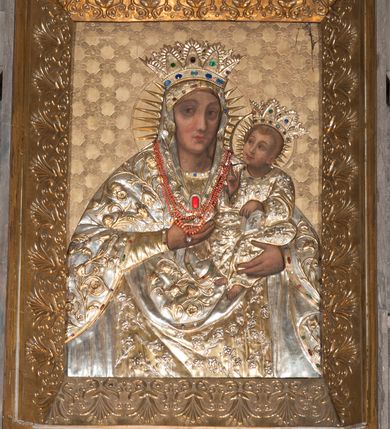 Zdjęcie nr 7: Ołtarz przyścienny, architektoniczny, pięcioosiowy, dwukondygnacyjny ze zwieńczeniem. Mensa kamienna, w formie stołu wsparta na parach kolumn o kostkowych kapitelach. Antepedium również kamienne, z umieszczonym w centrum monogramem IHS zwieńczonym krzyżem. Kondygnacja pierwsza artykułowana pięcioma arkadami ujętymi kolumienkami o kostkowych kapitelach. W arkadach umieszczone płaskorzeźbione postaci czterech ewangelistów: Jana, Marka, Łukasza i Mateusza. W osi środkowej prostopadłościenne, alabastrowe tabernakulum z tronem wystawienia nakrytym kamiennym baldachimem w formie kopuły wspartej na czterech kolumnach o kostkowych kapitelach. Na drzwiczkach umieszczony krzyż na tle glorii promienistej flankowany przez postaci klęczących aniołów. Kondygnacja druga artykułowana arkadami wspartymi na kolumnach o kostkowych kapitelach. W arkadach umieszczone dary wotywne. W osi środkowej znajduje się obraz Matki Boskiej z Dzieciątkiem w prostokątnej, złotej ramie. Struktura zwieńczona profilowanym gzymsem, ponad którym umieszczono płaskorzeźbione przedstawienie Baranka Apokaliptycznego ujętego medalionem zwieńczonym krzyżem oraz flankowanego przez postaci dwóch klęczących aniołów.
