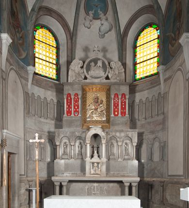 Zdjęcie nr 2: Ołtarz przyścienny, architektoniczny, pięcioosiowy, dwukondygnacyjny ze zwieńczeniem. Mensa kamienna, w formie stołu wsparta na parach kolumn o kostkowych kapitelach. Antepedium również kamienne, z umieszczonym w centrum monogramem IHS zwieńczonym krzyżem. Kondygnacja pierwsza artykułowana pięcioma arkadami ujętymi kolumienkami o kostkowych kapitelach. W arkadach umieszczone płaskorzeźbione postaci czterech ewangelistów: Jana, Marka, Łukasza i Mateusza. W osi środkowej prostopadłościenne, alabastrowe tabernakulum z tronem wystawienia nakrytym kamiennym baldachimem w formie kopuły wspartej na czterech kolumnach o kostkowych kapitelach. Na drzwiczkach umieszczony krzyż na tle glorii promienistej flankowany przez postaci klęczących aniołów. Kondygnacja druga artykułowana arkadami wspartymi na kolumnach o kostkowych kapitelach. W arkadach umieszczone dary wotywne. W osi środkowej znajduje się obraz Matki Boskiej z Dzieciątkiem w prostokątnej, złotej ramie. Struktura zwieńczona profilowanym gzymsem, ponad którym umieszczono płaskorzeźbione przedstawienie Baranka Apokaliptycznego ujętego medalionem zwieńczonym krzyżem oraz flankowanego przez postaci dwóch klęczących aniołów.
