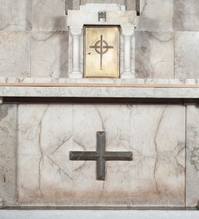 Zdjęcie nr 2: Umieszczone w osi ołtarza prostopadłościenne, alabastrowe tabernakulum ujęte parą półkolumn o gładkich trzonach i kostkowych kapitelach dźwigających prosty gzyms, na którym schodkowy tron wystawienia. Na gzymsie odlewana plakieta z umieszczoną na literze „H” hostią z krzyżem. Drzwiczki metalowe, gładkie z motywem krzyża.
