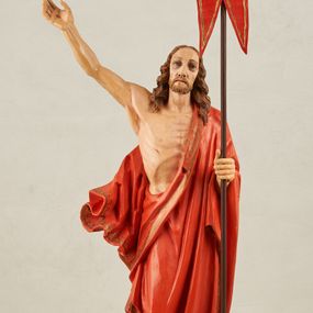 Zdjęcie nr 1: Figura pełnoplastyczna, ustawiona na niewysokim, prostopadłościennym postumencie o ściętych narożach. Chrystus przedstawiony całopostaciowo, frontalnie, w lekkim kontrapoście. Głowa nieznacznie uniesiona do góry, prawa ręką wyciągnięta ku górze, lewa wsparta na drzewcu chorągwi Zmartwychwstania. Twarz Zbawiciela szczupła, wydłużona o wyraźnych rysach. Duże, głęboko osadzone, szeroko otwarte oczy skierowane są ku górze. Wydatny, prosty nos oraz delikatnie zaznaczone czerwienią usta. Długie, brązowe włosy opadające w lokach na ramiona i plecy postaci. Na twarzy widoczny krótki, brązowy zarost. Odsłonięta klatka piersiowa z wyraźnie zaznaczoną muskulaturą oraz widoczną raną w boku. Na lewe ramię postaci luźno zarzucony obszerny, czerwony płaszcz ze złotą lamówką. Spod szat widoczne bose stopy. Czerwona chorągiew na długim, brązowym drzewcu zakończonym krzyżem. Figura w pełni polichromowana.