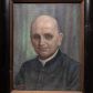 Zdjęcie nr 1: Portret w kształcie stojącego prostokąta. W centrum ukazane popiersie księdza Andrzeja Brasia zwrócone delikatnie w prawo. Twarz szeroka, o rysach starszego mężczyzny, z delikatnym zarostem, wąskimi ustami, długim i prostym nosem i małymi oczami. Włosy z łysiną, krótkie i siwe z tyłu głowy. Ksiądz ubrany w sutannę. Tło w kolorze niebieskim. Rama drewniana, malowana na czarno, boki ramy od wewnątrz złocone, a od zewnątrz zdobione motywem skręconego sznura. W lewym dolnym rogu sygnatura malowana na pomarańczowo „ST(ANISŁAW) CIĘŻADLIK / R(OK) 1966”.

