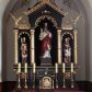 Zdjęcie nr 1: Nastawa ołtarzowa architektoniczna, trójosiowa, jednokondygnacyjna, na wysokim cokole. Ołtarz drewniany, prostopadłościenny; mensa drewniana. Antepedium w formie leżącego prostokąta ujęte w narożach kolumienkami, w polu trzy prostokątne płyciny, w środkowej monogram IHS na czerwonym tle otoczony promienistą glorią. Tabernakulum w formie prostopadłościennej skrzynki, ustawione na wysokim cokole, flankowane dwiem kolumienkami, zamknięte od góry gzymsem w kształcie łuku nadwieszonego. Drzwiczki w kształcie stojącego prostokąta, zamkniętego łukiem półkolistym, w polu płaskorzeźbione przedstawienie baranka paschalnego. Cokół nastawy trójosiowy, oś środkowa wydzielona pilastrami, na skrajach osi bocznych ćwierćkolumny z kapitelami w formie liści akantu. W polach osi bocznych kwadratowe płyciny wypełnione rozetami, w osi środkowej płycina w kształcie leżącego prostokąta. Cokół podtrzymuje nastawę, flankowaną dwiema parami kolumn, z których środkowe podtrzymują kopułę z przyczółkiem, a kolumny boczne figury aniołów. We wnęce środkowej figura Najświętszego Serca Jezusa, we wnęce lewej św. Wojciech, a po prawej św. Stanisław. Kolumny ustawione na bazach, przedzielone w połowie opaską, o trzonach zdobionych geometrycznymi motywami i kapitelach dekorowanych liśćmi akantu. U szczytu przyczółka duży kwiaton z zatkniętym krzyżem osadzonym na kuli. Gzymsy zdobione ażurową dekoracją roślinną. Łuki wnęk dekorowane arkadowaniami, w tym środkowa z maswerkami. Ponadto szczyt osi środkowej oraz gzyms nad osiami bocznymi wieńczy ornamentalny krenelaż. Struktura malowana w kolorze ciemnego brązu, ornamentyka i detale złocone. 

