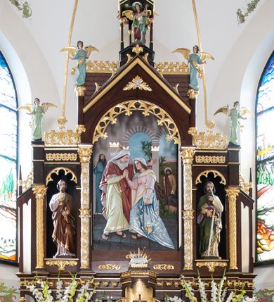 Zdjęcie nr 1: Nastawa ołtarzowa architektoniczna, trójosiowa, jednokondygnacyjna ze zwieńczeniem, na wysokim cokole. Ołtarz drewniany, prostopadłościenny; mensa drewniana. Antepedium w formie leżącego prostokąta ujęte w narożach półkolumienkami, w polu płaskorzeźbione przedstawienie Ostatniej Wieczerzy. Cokół retabulum z czterema pilastrami, stanowiącymi podstawę dla podpór. Osie wydzielone dwiema parami kolumn; środkowe wyższe od bocznych. W polu środkowym głęboka nisza z płaskorzeźbionym przedstawieniem Nawiedzenia Najświętszej Marii Panny i w formie stojącego prostokąta zamkniętego łukiem półkolistym, ujęta parą kolumn o kapitelach kompozytowych; arkada zamknięta trójkątnym szczytem, flankowanym wspornikami z figurkami aniołów; za nim fragment dachu. Osie boczne niższe, z niszami na figury św. Piotra i św. Pawła w formie stojącego prostokąta zamkniętego łukiem półkolistym; od zewnątrz ujęte półkolumienkami o kapitelach korynckich dźwigających fryz i postumenty dla figurek aniołów. Kondygnacja ujęta przyporami. Zwieńczenie w formie ośmiobocznego baldachimu opartego na arkadkach z figurą św. Michała Archanioła. Na szczycie łaciński krzyż o trójlistnie zakończonych ramionach. Na osiach zewnętrznych cokołu prześwity wypełnione wicią roślinną z motywem winnego grona. Cokół zakończony pasem z dekoracją roślinną. Trzony wewnętrznej pary kolumn dekorowane kratką z rozetami, w połowie wysokości ujęte koroną. Trzony zewnętrznej pary podpór zdobione ornamentem geometryczno-roślinnym. Łuki nisz dekorowane stylizowanym maswerkiem; pole szczytu rozetą, gzyms stylizowanymi żabkami. Osie boczne zwieńczone palmetami z rozetą. Kalenica dachu z ciągiem palmet.
Struktura w kolorze naturalnego drewna; ornamentyka i podpory złocone i srebrzone.