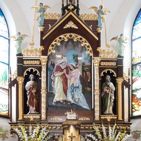 Zdjęcie nr 1: Nastawa ołtarzowa architektoniczna, trójosiowa, jednokondygnacyjna ze zwieńczeniem, na wysokim cokole. Ołtarz drewniany, prostopadłościenny; mensa drewniana. Antepedium w formie leżącego prostokąta ujęte w narożach półkolumienkami, w polu płaskorzeźbione przedstawienie Ostatniej Wieczerzy. Cokół retabulum z czterema pilastrami, stanowiącymi podstawę dla podpór. Osie wydzielone dwiema parami kolumn; środkowe wyższe od bocznych. W polu środkowym głęboka nisza z płaskorzeźbionym przedstawieniem Nawiedzenia Najświętszej Marii Panny i w formie stojącego prostokąta zamkniętego łukiem półkolistym, ujęta parą kolumn o kapitelach kompozytowych; arkada zamknięta trójkątnym szczytem, flankowanym wspornikami z figurkami aniołów; za nim fragment dachu. Osie boczne niższe, z niszami na figury św. Piotra i św. Pawła w formie stojącego prostokąta zamkniętego łukiem półkolistym; od zewnątrz ujęte półkolumienkami o kapitelach korynckich dźwigających fryz i postumenty dla figurek aniołów. Kondygnacja ujęta przyporami. Zwieńczenie w formie ośmiobocznego baldachimu opartego na arkadkach z figurą św. Michała Archanioła. Na szczycie łaciński krzyż o trójlistnie zakończonych ramionach. Na osiach zewnętrznych cokołu prześwity wypełnione wicią roślinną z motywem winnego grona. Cokół zakończony pasem z dekoracją roślinną. Trzony wewnętrznej pary kolumn dekorowane kratką z rozetami, w połowie wysokości ujęte koroną. Trzony zewnętrznej pary podpór zdobione ornamentem geometryczno-roślinnym. Łuki nisz dekorowane stylizowanym maswerkiem; pole szczytu rozetą, gzyms stylizowanymi żabkami. Osie boczne zwieńczone palmetami z rozetą. Kalenica dachu z ciągiem palmet.
Struktura w kolorze naturalnego drewna; ornamentyka i podpory złocone i srebrzone.