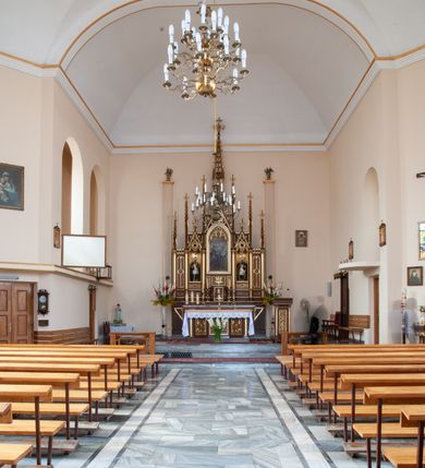 Zdjęcie nr 2: Ołtarz przyścienny, architektoniczny, pięcioosiowy, jednokondygnacyjny ze zwieńczeniem. Antepedium dekorowane płyciną w profilowanej ramie z umieszczonym centralnie czteroliściem oraz krzyżem. Tabernakulum metalowe, jednodrzwiczkowe z umieszczonym centralnie kielichem z hostią na tle kłosów oraz winorośli. Po bokach umieszczone litery „A” i „Ω” na tle krzyża każda. Nastawa posadowiona na wysokim cokole z płycinami wypełnionymi maswerkiem. Osie w układzie schodkowym z osią środkową wyższą i szerszą od bocznych, wydzielone wiązkami służek na postumentach w formie skręconych trzonów, z kapitelami dekorowanymi motywem ostroliścia. Służki zwieńczone pinaklami zakończonymi kwiatonami, w osi środkowej ażurowa wieżyczka w formie zbliżonej do pinakla zakończonego kwiatonem i krzyżem, tworząca baldachim nad figurą Dzieciątka Jezus. Osie środkowe zwieńczone trójkątnymi wimpergami wypełnionymi dekoracją maswerkową. W polu ołtarza obraz Trójcy Świętej w złoconej, profilowanej ramie w kształcie stojącego prostokąta zamkniętego łukiem ostrym z maswerkiem. Poniżej płycina z płaskorzeźbionym krzyżem na tle kłosów. W osiach drugiej i czwartej złocone nisze mieszczące figury św. Stanisława i Wojciecha. Nisze zamknięte od góry muszlami palmetowymi. Pod niszami płyciny wypełnione maswerkiem z fantazyjnym motywem geometrycznym. Osie skrajne wypełnione zdwojonymi blendami z rozetami pośrodku. Struktura ołtarza malowana na brązowo z elementami czerwieni, detal architektoniczny złocony. Figury w pełni polichromowane.