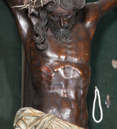 Zdjęcie nr 2: Chrystus ukazany w typie christo morte, w silnym zwisie, z głową opadającą na prawe ramię, nogami delikatnie ugiętymi w kolanach i skrzyżowanymi stopami przebitymi jednym gwoździem. Twarz pociągła, szczupła o wyraźnie zaznaczonych kościach policzkowych i długim nosie, z zamkniętymi oczami. Twarz okolona krótką, falowaną brodą. Włosy falowane, długie opadające na prawie ramię. Ciało szczupłe, o wyraźnie zarysowanej muskulaturze i klatce piersiowej. Perizonium gęsto drapowane w drobne fałdki, ściśle opinające biodra, przewiązane po prawej stronie, ze zwisem tkaniny sięgającym kolan.  Na górnej belce krzyża titulus w formie kartusza, z dekoracją małżowinową oraz napisem "INRI". Ciało polichromowane na brązowo, szaty złocone.