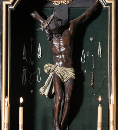 Zdjęcie nr 1: Chrystus ukazany w typie christo morte, w silnym zwisie, z głową opadającą na prawe ramię, nogami delikatnie ugiętymi w kolanach i skrzyżowanymi stopami przebitymi jednym gwoździem. Twarz pociągła, szczupła o wyraźnie zaznaczonych kościach policzkowych i długim nosie, z zamkniętymi oczami. Twarz okolona krótką, falowaną brodą. Włosy falowane, długie opadające na prawie ramię. Ciało szczupłe, o wyraźnie zarysowanej muskulaturze i klatce piersiowej. Perizonium gęsto drapowane w drobne fałdki, ściśle opinające biodra, przewiązane po prawej stronie, ze zwisem tkaniny sięgającym kolan.  Na górnej belce krzyża titulus w formie kartusza, z dekoracją małżowinową oraz napisem "INRI". Ciało polichromowane na brązowo, szaty złocone.