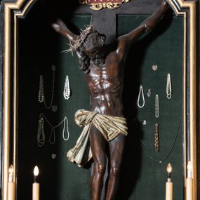 Zdjęcie nr 1: Chrystus ukazany w typie christo morte, w silnym zwisie, z głową opadającą na prawe ramię, nogami delikatnie ugiętymi w kolanach i skrzyżowanymi stopami przebitymi jednym gwoździem. Twarz pociągła, szczupła o wyraźnie zaznaczonych kościach policzkowych i długim nosie, z zamkniętymi oczami. Twarz okolona krótką, falowaną brodą. Włosy falowane, długie opadające na prawie ramię. Ciało szczupłe, o wyraźnie zarysowanej muskulaturze i klatce piersiowej. Perizonium gęsto drapowane w drobne fałdki, ściśle opinające biodra, przewiązane po prawej stronie, ze zwisem tkaniny sięgającym kolan.  Na górnej belce krzyża titulus w formie kartusza, z dekoracją małżowinową oraz napisem "INRI". Ciało polichromowane na brązowo, szaty złocone.