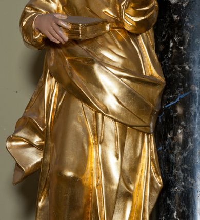 Zdjęcie nr 13: Ołtarz jednoosiowy, jednokondygnacyjny ze zwieńczeniem. Mensa marmurowa, antepedium z płyciną w kształcie leżącego prostokąta o ściętych ćwierćkoliście narożach oraz drewnianym i płaskorzeźbionym przedstawieniem Baranka Eucharystycznego leżącego na księdze, na obłoku, w glorii. Nastawa ujęta parą stojących na ukośnie dostawionych postumentach kolumn kompozytowych na tle zwielokrotnionych pilastrów, dźwigających pełne belkowanie z wydatnym gzymsem, wyłamane na osi podpór oraz przerwany półkolisty przyczółek. Belkowanie rozerwane owalnym polem z obrazem ukazującym św. Jana Nepomucena. Po zewnętrznej stronie podpór figury św. Anny i św. Joachima na wydatnych wspornikach. W polu środkowym profilowana rama w formie stojącego prostokąta z obrazem św. Wawrzyńca. Zwieńczenie w formie stojącego prostokąta, ujęte zdwojonymi pilastrami; zamknięte gzymsem przyjmującym kształt łuku w ośli grzbiet zakończonego stylizowaną palmetą. W polu profilowana rama w formie stojącego prostokąta o ściętych narożach z obrazem „Ofiarowanie Marii do świątyni”. Trzony pilastrów dekorowane kampanulami. Imposty dekorowane z trzech stron rozetami, fryz nad polem środkowym retabulum akantem. Kondygnacja ujęta uszami utworzonymi z suchego akantu z motywem słonecznika. Trzony pilastrów zwieńczenia dekorowane płycinami z kampanulami. Pole obrazowe flankowane liśćmi palmowymi, zwieńczone kamienną muszlą. Na gzymsie zwieńczenia umieszczono festony. Ornamentyka, profilowania i kapitele kolumn są złocone.