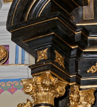 Zdjęcie nr 8: Ołtarz jednoosiowy, jednokondygnacyjny ze zwieńczeniem. Mensa marmurowa, antepedium z płyciną w kształcie leżącego prostokąta o ściętych ćwierćkoliście narożach oraz drewnianym i płaskorzeźbionym przedstawieniem Baranka Eucharystycznego leżącego na księdze, na obłoku, w glorii. Nastawa ujęta parą stojących na ukośnie dostawionych postumentach kolumn kompozytowych na tle zwielokrotnionych pilastrów, dźwigających pełne belkowanie z wydatnym gzymsem, wyłamane na osi podpór oraz przerwany półkolisty przyczółek. Belkowanie rozerwane owalnym polem z obrazem ukazującym św. Jana Nepomucena. Po zewnętrznej stronie podpór figury św. Anny i św. Joachima na wydatnych wspornikach. W polu środkowym profilowana rama w formie stojącego prostokąta z obrazem św. Wawrzyńca. Zwieńczenie w formie stojącego prostokąta, ujęte zdwojonymi pilastrami; zamknięte gzymsem przyjmującym kształt łuku w ośli grzbiet zakończonego stylizowaną palmetą. W polu profilowana rama w formie stojącego prostokąta o ściętych narożach z obrazem „Ofiarowanie Marii do świątyni”. Trzony pilastrów dekorowane kampanulami. Imposty dekorowane z trzech stron rozetami, fryz nad polem środkowym retabulum akantem. Kondygnacja ujęta uszami utworzonymi z suchego akantu z motywem słonecznika. Trzony pilastrów zwieńczenia dekorowane płycinami z kampanulami. Pole obrazowe flankowane liśćmi palmowymi, zwieńczone kamienną muszlą. Na gzymsie zwieńczenia umieszczono festony. Ornamentyka, profilowania i kapitele kolumn są złocone.