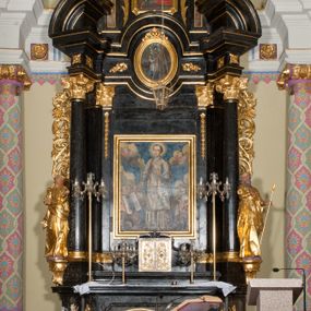 Zdjęcie nr 1: Ołtarz jednoosiowy, jednokondygnacyjny ze zwieńczeniem. Mensa marmurowa, antepedium z płyciną w kształcie leżącego prostokąta o ściętych ćwierćkoliście narożach oraz drewnianym i płaskorzeźbionym przedstawieniem Baranka Eucharystycznego leżącego na księdze, na obłoku, w glorii. Nastawa ujęta parą stojących na ukośnie dostawionych postumentach kolumn kompozytowych na tle zwielokrotnionych pilastrów, dźwigających pełne belkowanie z wydatnym gzymsem, wyłamane na osi podpór oraz przerwany półkolisty przyczółek. Belkowanie rozerwane owalnym polem z obrazem ukazującym św. Jana Nepomucena. Po zewnętrznej stronie podpór figury św. Anny i św. Joachima na wydatnych wspornikach. W polu środkowym profilowana rama w formie stojącego prostokąta z obrazem św. Wawrzyńca. Zwieńczenie w formie stojącego prostokąta, ujęte zdwojonymi pilastrami; zamknięte gzymsem przyjmującym kształt łuku w ośli grzbiet zakończonego stylizowaną palmetą. W polu profilowana rama w formie stojącego prostokąta o ściętych narożach z obrazem „Ofiarowanie Marii do świątyni”. Trzony pilastrów dekorowane kampanulami. Imposty dekorowane z trzech stron rozetami, fryz nad polem środkowym retabulum akantem. Kondygnacja ujęta uszami utworzonymi z suchego akantu z motywem słonecznika. Trzony pilastrów zwieńczenia dekorowane płycinami z kampanulami. Pole obrazowe flankowane liśćmi palmowymi, zwieńczone kamienną muszlą. Na gzymsie zwieńczenia umieszczono festony. Ornamentyka, profilowania i kapitele kolumn są złocone.