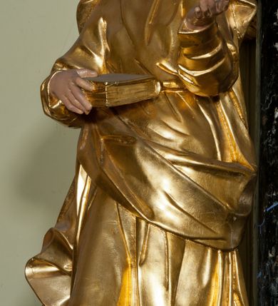 Zdjęcie nr 21: Ołtarz jednoosiowy, jednokondygnacyjny ze zwieńczeniem. Mensa marmurowa, antepedium z płyciną w kształcie leżącego prostokąta o ściętych ćwierćkoliście narożach oraz drewnianym i płaskorzeźbionym przedstawieniem Baranka Eucharystycznego leżącego na księdze, na obłoku, w glorii. Nastawa ujęta parą stojących na ukośnie dostawionych postumentach kolumn kompozytowych na tle zwielokrotnionych pilastrów, dźwigających pełne belkowanie z wydatnym gzymsem, wyłamane na osi podpór oraz przerwany półkolisty przyczółek. Belkowanie rozerwane owalnym polem z obrazem ukazującym św. Jana Nepomucena. Po zewnętrznej stronie podpór figury św. Anny i św. Joachima na wydatnych wspornikach. W polu środkowym profilowana rama w formie stojącego prostokąta z obrazem św. Wawrzyńca. Zwieńczenie w formie stojącego prostokąta, ujęte zdwojonymi pilastrami; zamknięte gzymsem przyjmującym kształt łuku w ośli grzbiet zakończonego stylizowaną palmetą. W polu profilowana rama w formie stojącego prostokąta o ściętych narożach z obrazem „Ofiarowanie Marii do świątyni”. Trzony pilastrów dekorowane kampanulami. Imposty dekorowane z trzech stron rozetami, fryz nad polem środkowym retabulum akantem. Kondygnacja ujęta uszami utworzonymi z suchego akantu z motywem słonecznika. Trzony pilastrów zwieńczenia dekorowane płycinami z kampanulami. Pole obrazowe flankowane liśćmi palmowymi, zwieńczone kamienną muszlą. Na gzymsie zwieńczenia umieszczono festony. Ornamentyka, profilowania i kapitele kolumn są złocone.