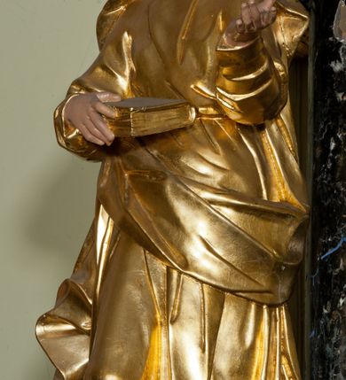 Zdjęcie nr 27: Ołtarz jednoosiowy, jednokondygnacyjny ze zwieńczeniem. Mensa marmurowa, antepedium z płyciną w kształcie leżącego prostokąta o ściętych ćwierćkoliście narożach oraz drewnianym i płaskorzeźbionym przedstawieniem Baranka Eucharystycznego leżącego na księdze, na obłoku, w glorii. Nastawa ujęta parą stojących na ukośnie dostawionych postumentach kolumn kompozytowych na tle zwielokrotnionych pilastrów, dźwigających pełne belkowanie z wydatnym gzymsem, wyłamane na osi podpór oraz przerwany półkolisty przyczółek. Belkowanie rozerwane owalnym polem z obrazem ukazującym św. Jana Nepomucena. Po zewnętrznej stronie podpór figury św. Anny i św. Joachima na wydatnych wspornikach. W polu środkowym profilowana rama w formie stojącego prostokąta z obrazem św. Wawrzyńca. Zwieńczenie w formie stojącego prostokąta, ujęte zdwojonymi pilastrami; zamknięte gzymsem przyjmującym kształt łuku w ośli grzbiet zakończonego stylizowaną palmetą. W polu profilowana rama w formie stojącego prostokąta o ściętych narożach z obrazem „Ofiarowanie Marii do świątyni”. Trzony pilastrów dekorowane kampanulami. Imposty dekorowane z trzech stron rozetami, fryz nad polem środkowym retabulum akantem. Kondygnacja ujęta uszami utworzonymi z suchego akantu z motywem słonecznika. Trzony pilastrów zwieńczenia dekorowane płycinami z kampanulami. Pole obrazowe flankowane liśćmi palmowymi, zwieńczone kamienną muszlą. Na gzymsie zwieńczenia umieszczono festony. Ornamentyka, profilowania i kapitele kolumn są złocone.