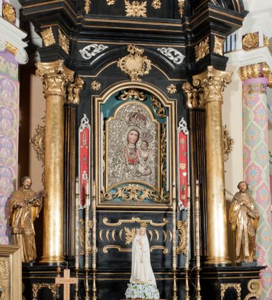Zdjęcie nr 2: Ołtarz architektoniczny, jednoosiowy, jednokondygnacyjny ze zwieńczeniem. Ołtarz drewniany prostopadłościenny, mensa drewniana z portatylem z marmuru dębnickiego. Antepedium dekorowane płyciną w formie leżącego prostokąta o wklęsłych narożach z monogramem maryjnym w polu. Na ściankach bocznych ołtarza płyciny w formie kwadratu o wklęsłych narożach. Retabulum jest ujęte parą ustawionych pod kątem na cokołach kolumn o kompozytowych kapitelach stojących na tle zwielokrotnionych pilastrów o kanelowanych trzonach, dźwigających pełne belkowanie z wydatnym gzymsem, wyłamane na osi podpór oraz przerwany, półkolisty przyczółek z figurami siedzących puttów; architraw nad polem środkowym przybiera kształt łuku odcinkowego. Po zewnętrznej stronie kolumn figury św. Jana Nepomucena i św. Jana Kantego na wydatnych konsolach. W polu środkowym nisza ujęta profilowaną ramą w formie stojącego prostokąta zamkniętego łukiem odcinkowym nadwieszonym z obrazem Matki Boskiej z Dzieciątkiem. Zwieńczenie w formie stojącego prostokąta ujęte zwielokrotnionymi pilastrami podtrzymującymi profilowany gzyms w kształcie łuku oślego. W polu owalny obraz "Św. Andrzej". Cokoły dekorowane płycinami utworzonymi z ornamentu roślinnego, konsole zdobione muszlą o kształcie falbany. Nad polem środkowym rocaille'owy kartusz, flankowany akantem. U spodu obrazu dekoracja roślinno-geometryczna z rozetą ujętą rocaiile'm. Obraz flankowany gablotami z wotami w ramie utworzonej z akantu i sznura. Fryz impostów zdobiony rozetami; nad polem środkowym akantem. Kondygnacja ujęta ażurowymi uszami utworzonymi z rocaille'ów i kwiatów róż. Trzony pilastrów zwieńczenia dekorowane rocaille'em i roślinnymi festonami. Pole obrazowe otoczone fragmentami rocaille'u, zwieńczone muszlą. Nad zwieńczeniem mitra książęca. Struktura polichromowana w kolorze czarnym; kolumny, ornamentyka i profile złocone.
