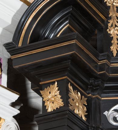 Zdjęcie nr 9: Ołtarz architektoniczny, jednoosiowy, jednokondygnacyjny ze zwieńczeniem. Ołtarz drewniany prostopadłościenny, mensa drewniana z portatylem z marmuru dębnickiego. Antepedium dekorowane płyciną w formie leżącego prostokąta o wklęsłych narożach z monogramem maryjnym w polu. Na ściankach bocznych ołtarza płyciny w formie kwadratu o wklęsłych narożach. Retabulum jest ujęte parą ustawionych pod kątem na cokołach kolumn o kompozytowych kapitelach stojących na tle zwielokrotnionych pilastrów o kanelowanych trzonach, dźwigających pełne belkowanie z wydatnym gzymsem, wyłamane na osi podpór oraz przerwany, półkolisty przyczółek z figurami siedzących puttów; architraw nad polem środkowym przybiera kształt łuku odcinkowego. Po zewnętrznej stronie kolumn figury św. Jana Nepomucena i św. Jana Kantego na wydatnych konsolach. W polu środkowym nisza ujęta profilowaną ramą w formie stojącego prostokąta zamkniętego łukiem odcinkowym nadwieszonym z obrazem Matki Boskiej z Dzieciątkiem. Zwieńczenie w formie stojącego prostokąta ujęte zwielokrotnionymi pilastrami podtrzymującymi profilowany gzyms w kształcie łuku oślego. W polu owalny obraz "Św. Andrzej". Cokoły dekorowane płycinami utworzonymi z ornamentu roślinnego, konsole zdobione muszlą o kształcie falbany. Nad polem środkowym rocaille'owy kartusz, flankowany akantem. U spodu obrazu dekoracja roślinno-geometryczna z rozetą ujętą rocaiile'm. Obraz flankowany gablotami z wotami w ramie utworzonej z akantu i sznura. Fryz impostów zdobiony rozetami; nad polem środkowym akantem. Kondygnacja ujęta ażurowymi uszami utworzonymi z rocaille'ów i kwiatów róż. Trzony pilastrów zwieńczenia dekorowane rocaille'em i roślinnymi festonami. Pole obrazowe otoczone fragmentami rocaille'u, zwieńczone muszlą. Nad zwieńczeniem mitra książęca. Struktura polichromowana w kolorze czarnym; kolumny, ornamentyka i profile złocone.