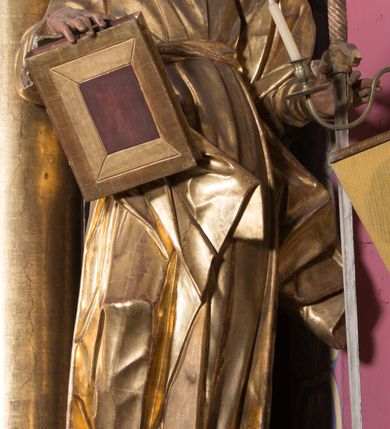 Zdjęcie nr 19: Ołtarz architektoniczny, jednoosiowy, jednokondygnacyjny ze zwieńczeniem. Ołtarz drewniany prostopadłościenny, mensa drewniana z portatylem z marmuru dębnickiego. W ołtarzu nisza z Grobem Pańskim, zakryta antepedium dekorowanym ramą w formie leżącego prostokąta o wklęsłych narożach z monogramem IHS w polu. Na ściankach bocznych ołtarza płyciny w formie kwadratu o wklęsłych narożach. Retabulum jest ujęte parą kompozytowych kolumn ustawionych na ukośnych cokołach stojących, na tle zwielokrotnionych pilastrów o kanelowanych trzonach, dźwigających pełne belkowanie z wydatnym gzymsem wyłamane na osi podpór oraz przerwany półkolisty przyczółek z figurami siedzących puttów; architraw nad polem środkowym przybiera kształt łuku odcinkowego. Po zewnętrznej stronie kolumn figury św. Piotra i św. Pawła stojące na wydatnych konsolach. W polu środkowym nisza ujęta profilowaną ramą w formie stojącego prostokąta zamkniętego łukiem odcinkowym nadwieszonym z figurą Chrystusa Ukrzyżowanego. Zwieńczenie w formie stojącego prostokąta ujęte zwielokrotnionymi pilastrami podtrzymującymi profilowany gzyms przyjmujący kształt łuku oślego. W polu owalne pole z obrazem „Zesłanie Ducha Świętego”. Cokoły dekorowane płycinami utworzonymi z ornamentu roślinnego, zaś konsole zdobione muszlą o kształcie falbany. Nad polem środkowym rocaille&#039;owy kartusz z napisem: „IXEUS”, flankowany akantem. U spodu obrazu prostokątna płycina. Fryz zdobiony rozetami. Kondygnacja ujęta ażurowymi uszami utworzonymi z suchego akantu, wstęgi, rocaille&#039;u i rozet. Trzony pilastrów zwieńczenia dekorowane rocaille&#039;em i roślinnymi festonami. Pole obrazowe otoczone fragmentami rocaille&#039;u, zwieńczone muszlą. Ponad zwieńczeniem krzyż lub wazon nakryty sukienką na puszkę. Struktura polichromowana w kolorze czarnym; kolumny, ornamentyka i profile złocone.