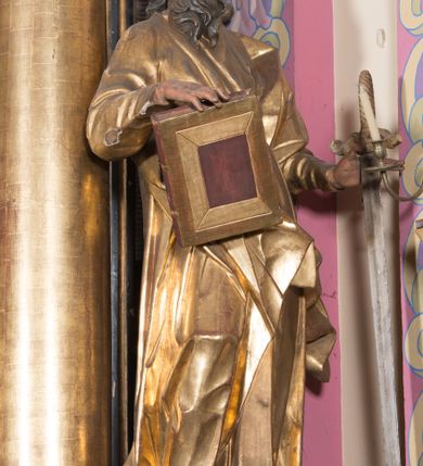 Zdjęcie nr 24: Ołtarz architektoniczny, jednoosiowy, jednokondygnacyjny ze zwieńczeniem. Ołtarz drewniany prostopadłościenny, mensa drewniana z portatylem z marmuru dębnickiego. W ołtarzu nisza z Grobem Pańskim, zakryta antepedium dekorowanym ramą w formie leżącego prostokąta o wklęsłych narożach z monogramem IHS w polu. Na ściankach bocznych ołtarza płyciny w formie kwadratu o wklęsłych narożach. Retabulum jest ujęte parą kompozytowych kolumn ustawionych na ukośnych cokołach stojących, na tle zwielokrotnionych pilastrów o kanelowanych trzonach, dźwigających pełne belkowanie z wydatnym gzymsem wyłamane na osi podpór oraz przerwany półkolisty przyczółek z figurami siedzących puttów; architraw nad polem środkowym przybiera kształt łuku odcinkowego. Po zewnętrznej stronie kolumn figury św. Piotra i św. Pawła stojące na wydatnych konsolach. W polu środkowym nisza ujęta profilowaną ramą w formie stojącego prostokąta zamkniętego łukiem odcinkowym nadwieszonym z figurą Chrystusa Ukrzyżowanego. Zwieńczenie w formie stojącego prostokąta ujęte zwielokrotnionymi pilastrami podtrzymującymi profilowany gzyms przyjmujący kształt łuku oślego. W polu owalne pole z obrazem „Zesłanie Ducha Świętego”. Cokoły dekorowane płycinami utworzonymi z ornamentu roślinnego, zaś konsole zdobione muszlą o kształcie falbany. Nad polem środkowym rocaille'owy kartusz z napisem: „IXEUS”, flankowany akantem. U spodu obrazu prostokątna płycina. Fryz zdobiony rozetami. Kondygnacja ujęta ażurowymi uszami utworzonymi z suchego akantu, wstęgi, rocaille'u i rozet. Trzony pilastrów zwieńczenia dekorowane rocaille'em i roślinnymi festonami. Pole obrazowe otoczone fragmentami rocaille'u, zwieńczone muszlą. Ponad zwieńczeniem krzyż lub wazon nakryty sukienką na puszkę. Struktura polichromowana w kolorze czarnym; kolumny, ornamentyka i profile złocone.