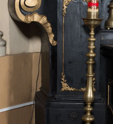 Zdjęcie nr 10: Ołtarz architektoniczny, jednoosiowy, jednokondygnacyjny ze zwieńczeniem. Ołtarz drewniany prostopadłościenny, mensa drewniana z portatylem z marmuru dębnickiego. W ołtarzu nisza z Grobem Pańskim, zakryta antepedium dekorowanym ramą w formie leżącego prostokąta o wklęsłych narożach z monogramem IHS w polu. Na ściankach bocznych ołtarza płyciny w formie kwadratu o wklęsłych narożach. Retabulum jest ujęte parą kompozytowych kolumn ustawionych na ukośnych cokołach stojących, na tle zwielokrotnionych pilastrów o kanelowanych trzonach, dźwigających pełne belkowanie z wydatnym gzymsem wyłamane na osi podpór oraz przerwany półkolisty przyczółek z figurami siedzących puttów; architraw nad polem środkowym przybiera kształt łuku odcinkowego. Po zewnętrznej stronie kolumn figury św. Piotra i św. Pawła stojące na wydatnych konsolach. W polu środkowym nisza ujęta profilowaną ramą w formie stojącego prostokąta zamkniętego łukiem odcinkowym nadwieszonym z figurą Chrystusa Ukrzyżowanego. Zwieńczenie w formie stojącego prostokąta ujęte zwielokrotnionymi pilastrami podtrzymującymi profilowany gzyms przyjmujący kształt łuku oślego. W polu owalne pole z obrazem „Zesłanie Ducha Świętego”. Cokoły dekorowane płycinami utworzonymi z ornamentu roślinnego, zaś konsole zdobione muszlą o kształcie falbany. Nad polem środkowym rocaille&#039;owy kartusz z napisem: „IXEUS”, flankowany akantem. U spodu obrazu prostokątna płycina. Fryz zdobiony rozetami. Kondygnacja ujęta ażurowymi uszami utworzonymi z suchego akantu, wstęgi, rocaille&#039;u i rozet. Trzony pilastrów zwieńczenia dekorowane rocaille&#039;em i roślinnymi festonami. Pole obrazowe otoczone fragmentami rocaille&#039;u, zwieńczone muszlą. Ponad zwieńczeniem krzyż lub wazon nakryty sukienką na puszkę. Struktura polichromowana w kolorze czarnym; kolumny, ornamentyka i profile złocone.