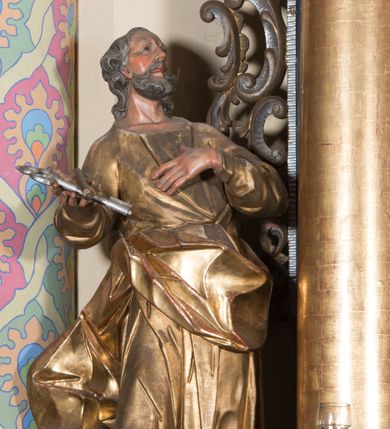 Zdjęcie nr 31: Ołtarz architektoniczny, jednoosiowy, jednokondygnacyjny ze zwieńczeniem. Ołtarz drewniany prostopadłościenny, mensa drewniana z portatylem z marmuru dębnickiego. W ołtarzu nisza z Grobem Pańskim, zakryta antepedium dekorowanym ramą w formie leżącego prostokąta o wklęsłych narożach z monogramem IHS w polu. Na ściankach bocznych ołtarza płyciny w formie kwadratu o wklęsłych narożach. Retabulum jest ujęte parą kompozytowych kolumn ustawionych na ukośnych cokołach stojących, na tle zwielokrotnionych pilastrów o kanelowanych trzonach, dźwigających pełne belkowanie z wydatnym gzymsem wyłamane na osi podpór oraz przerwany półkolisty przyczółek z figurami siedzących puttów; architraw nad polem środkowym przybiera kształt łuku odcinkowego. Po zewnętrznej stronie kolumn figury św. Piotra i św. Pawła stojące na wydatnych konsolach. W polu środkowym nisza ujęta profilowaną ramą w formie stojącego prostokąta zamkniętego łukiem odcinkowym nadwieszonym z figurą Chrystusa Ukrzyżowanego. Zwieńczenie w formie stojącego prostokąta ujęte zwielokrotnionymi pilastrami podtrzymującymi profilowany gzyms przyjmujący kształt łuku oślego. W polu owalne pole z obrazem „Zesłanie Ducha Świętego”. Cokoły dekorowane płycinami utworzonymi z ornamentu roślinnego, zaś konsole zdobione muszlą o kształcie falbany. Nad polem środkowym rocaille'owy kartusz z napisem: „IXEUS”, flankowany akantem. U spodu obrazu prostokątna płycina. Fryz zdobiony rozetami. Kondygnacja ujęta ażurowymi uszami utworzonymi z suchego akantu, wstęgi, rocaille'u i rozet. Trzony pilastrów zwieńczenia dekorowane rocaille'em i roślinnymi festonami. Pole obrazowe otoczone fragmentami rocaille'u, zwieńczone muszlą. Ponad zwieńczeniem krzyż lub wazon nakryty sukienką na puszkę. Struktura polichromowana w kolorze czarnym; kolumny, ornamentyka i profile złocone.