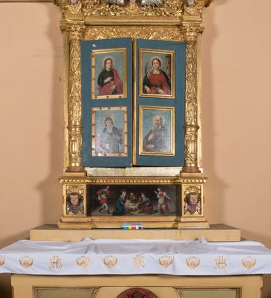 Zdjęcie nr 2: Ołtarz prostopadłościenny, drewniany. Mensa drewniana, antepedium dekorowane płyciną z okrągłym medalionem i równoramiennym krzyżem o trójlistnym zakończeniu ramion w glorii promienistej. Nastawa ołtarzowa architektoniczna, jednoosiowa, jednokondygnacyjna ze skrzydłami. Jest wsparta na predelli ujętej cokołami z główkami aniołków na tle muszli, z podwieszonymi pod ich szyjami chustami, zwieńczonej kostkowaniem. Nastawa flankowana korynckimi kolumnami, podtrzymującymi szerokie belkowanie. Trzony kolumn ujęte pierścieniem w jednej trzeciej wysokości, u dołu dekorowane ornamentem okuciowym z kaboszonem, u góry płaskorzeźbioną stylizowaną arabeską. W skrzydłach szerokie ramy wokół obrazów wypełnione ornamentem roślinnym, boczną krawędź zdobi pas cekinów. Architraw i fryz zdobiony ornamentem roślinnym; w partii fryzu trzy uskrzydlone główki anielskie. Gzyms u spodu dekorowany kostkowaniem i ornamentem sznurowym. Na gzymsie szczyt, utworzony z ornamentu okuciowego; na belkowaniu, na osiach podpór cokoły z figurami aniołów. Struktura w całości złocona. W polu środkowym św. Anna Samotrzeć, w predelli scena ukazująca „Pokłon pasterzy”, a na skrzydłach przedstawienia św. Antoniego, św. Barbary (lewe skrzydło), św. Franciszka i św. Jana Kantego (prawe skrzydło); na awersie św. Jana Ewangelisty i św. Elżbiety Węgierskiej (lewe skrzydło) oraz św. Barbary i niezidentyfikowanego świętego (prawe skrzydło). 
