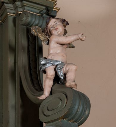 Zdjęcie nr 8: Nastawa architektoniczna, jednokondygnacyjna, jednoosiowa ze zwieńczeniem. Ołtarz sarkofagowy, wybrzuszony, z drewnianą mensą i drewnianym portatylem integralnie zespolony z cokołem retabulum. Nastawa wsparta na ukośnie ustawionych postumentach z filarami i stojącymi przed nimi oraz z boku wolnostojącymi kolumnami z głowicami akantowymi, podtrzymującymi wspólnie, wznoszące się nad nimi belkowanie. Zwieńczenie ujęte ukośnie posadowionymi spływami wolutowymi podtrzymującymi gzyms wyłamujący się pośrodku łukowato. W środku nastawy głęboka wnęka w profilowanym obramieniu z motywem skręconego sznura, prostokątna o ściętych górą narożach, zamknięta łukiem półkolistym nadwieszonym. W niej obraz przedstawiający św. Józefa z Dzieciątkiem, w ramie powielającej wykrój wnęki, z drobnymi rocaille'ami na bokach. W zwieńczeniu wnęka prostokątna w profilowanym obramieniu, z motywem skręconego sznura, ujęta po bokach kłosami zbóż, a zwieńczona motywem akantu. W niej obraz prostokątny obraz z wyobrażeniem św. Stanisława Kostki. Na spływach wolutowych uskrzydlone nagie aniołki z przepaską na biodrach. Nad wnęką w środkowej części ołtarza wypukły kartusz ujęty rocaile'm, drobne rocaille nad wnęką i na filarach, w partii cokołu utworzona z motywu rocaille'owego konsola.  Kolorystyka  struktury w odcieniu  zieleni wpadającej w szarość, partie detalu architektonicznego i ornamentyka  złocone.