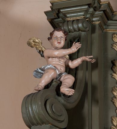 Zdjęcie nr 7: Nastawa architektoniczna, jednokondygnacyjna, jednoosiowa ze zwieńczeniem. Ołtarz sarkofagowy, wybrzuszony, z drewnianą mensą i drewnianym portatylem integralnie zespolony z cokołem retabulum. Nastawa wsparta na ukośnie ustawionych postumentach z filarami i stojącymi przed nimi oraz z boku wolnostojącymi kolumnami z głowicami akantowymi, podtrzymującymi wspólnie, wznoszące się nad nimi belkowanie. Zwieńczenie ujęte ukośnie posadowionymi spływami wolutowymi podtrzymującymi gzyms wyłamujący się pośrodku łukowato. W środku nastawy głęboka wnęka w profilowanym obramieniu z motywem skręconego sznura, prostokątna o ściętych górą narożach, zamknięta łukiem półkolistym nadwieszonym. W niej obraz przedstawiający św. Józefa z Dzieciątkiem, w ramie powielającej wykrój wnęki, z drobnymi rocaille'ami na bokach. W zwieńczeniu wnęka prostokątna w profilowanym obramieniu, z motywem skręconego sznura, ujęta po bokach kłosami zbóż, a zwieńczona motywem akantu. W niej obraz prostokątny obraz z wyobrażeniem św. Stanisława Kostki. Na spływach wolutowych uskrzydlone nagie aniołki z przepaską na biodrach. Nad wnęką w środkowej części ołtarza wypukły kartusz ujęty rocaile'm, drobne rocaille nad wnęką i na filarach, w partii cokołu utworzona z motywu rocaille'owego konsola.  Kolorystyka  struktury w odcieniu  zieleni wpadającej w szarość, partie detalu architektonicznego i ornamentyka  złocone.