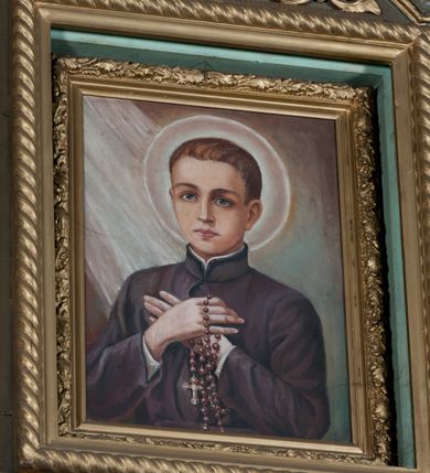 Zdjęcie nr 12: Nastawa architektoniczna, jednokondygnacyjna, jednoosiowa ze zwieńczeniem. Ołtarz sarkofagowy, wybrzuszony, z drewnianą mensą i drewnianym portatylem integralnie zespolony z cokołem retabulum. Nastawa wsparta na ukośnie ustawionych postumentach z filarami i stojącymi przed nimi oraz z boku wolnostojącymi kolumnami z głowicami akantowymi, podtrzymującymi wspólnie, wznoszące się nad nimi belkowanie. Zwieńczenie ujęte ukośnie posadowionymi spływami wolutowymi podtrzymującymi gzyms wyłamujący się pośrodku łukowato. W środku nastawy głęboka wnęka w profilowanym obramieniu z motywem skręconego sznura, prostokątna o ściętych górą narożach, zamknięta łukiem półkolistym nadwieszonym. W niej obraz przedstawiający św. Józefa z Dzieciątkiem, w ramie powielającej wykrój wnęki, z drobnymi rocaille'ami na bokach. W zwieńczeniu wnęka prostokątna w profilowanym obramieniu, z motywem skręconego sznura, ujęta po bokach kłosami zbóż, a zwieńczona motywem akantu. W niej obraz prostokątny obraz z wyobrażeniem św. Stanisława Kostki. Na spływach wolutowych uskrzydlone nagie aniołki z przepaską na biodrach. Nad wnęką w środkowej części ołtarza wypukły kartusz ujęty rocaile'm, drobne rocaille nad wnęką i na filarach, w partii cokołu utworzona z motywu rocaille'owego konsola.  Kolorystyka  struktury w odcieniu  zieleni wpadającej w szarość, partie detalu architektonicznego i ornamentyka  złocone.