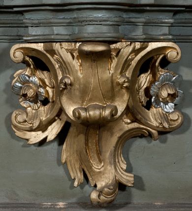 Zdjęcie nr 5: Nastawa architektoniczna, jednokondygnacyjna, jednoosiowa ze zwieńczeniem. Ołtarz sarkofagowy, wybrzuszony, z drewnianą mensą i drewnianym portatylem integralnie zespolony z cokołem retabulum. Nastawa wsparta na ukośnie ustawionych postumentach z filarami i stojącymi przed nimi oraz z boku wolnostojącymi kolumnami z głowicami akantowymi, podtrzymującymi wspólnie, wznoszące się nad nimi belkowanie. Zwieńczenie ujęte ukośnie posadowionymi spływami wolutowymi podtrzymującymi gzyms wyłamujący się pośrodku łukowato. W środku nastawy głęboka wnęka w profilowanym obramieniu z motywem skręconego sznura, prostokątna o ściętych górą narożach, zamknięta łukiem półkolistym nadwieszonym. W niej obraz przedstawiający św. Józefa z Dzieciątkiem, w ramie powielającej wykrój wnęki, z drobnymi rocaille'ami na bokach. W zwieńczeniu wnęka prostokątna w profilowanym obramieniu, z motywem skręconego sznura, ujęta po bokach kłosami zbóż, a zwieńczona motywem akantu. W niej obraz prostokątny obraz z wyobrażeniem św. Stanisława Kostki. Na spływach wolutowych uskrzydlone nagie aniołki z przepaską na biodrach. Nad wnęką w środkowej części ołtarza wypukły kartusz ujęty rocaile'm, drobne rocaille nad wnęką i na filarach, w partii cokołu utworzona z motywu rocaille'owego konsola.  Kolorystyka  struktury w odcieniu  zieleni wpadającej w szarość, partie detalu architektonicznego i ornamentyka  złocone.