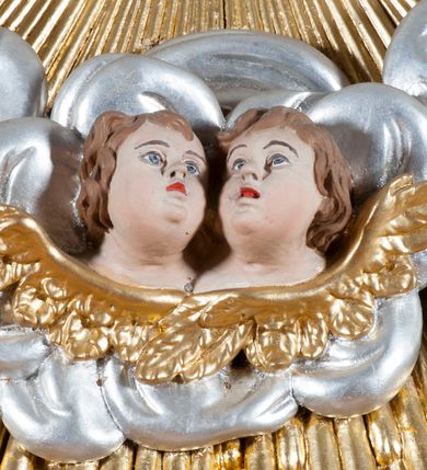 Zdjęcie nr 3: Ołtarz jednoosiowy, jednokondygnacyjny ze zwieńczeniem. Mensa sarkofagowa. Nastawa osadzona na cokole,  flankowana dwoma spływami wolutowymi, obficie dekorowanymi rocaille&#039;ami. W polu głównym, w płytkiej niszy w kształcie stojącego prostokąta zamkniętego łukiem wklęsło-wypukłym z uskokami obraz Matki Boskiej Niepokalanie Poczętej. W dolnej części kondygnacji prostokątne pole utworzone z rocaille&#039;i. Zwieńczenie o wielkości kondygnacji w formie promienistej glorii, z gołębicą Ducha Świętego w polu, wokół której uskrzydlone główki aniołków na tle obłoków oraz rocaille&#039;e spięte u góry koroną w typie otwartym. Struktura polichromowana na kolor jasno i ciemnobeżowy, detale, ornamentyka i profilowania złocone. Taki sam ornament zdobi narożniki mensy, ryzality w cokole, ujmuje również pole obrazowe na jego dłuższych bokach oraz w zwieńczeniu pola.