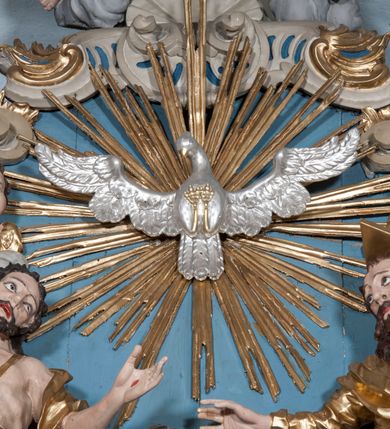 Zdjęcie nr 30: Nastawa ołtarzowa architektoniczna, jednoosiowa, jednokondygnacyjna ze zwieńczeniem, z bramkami i z rocaille'owymi uszami. Tabernakulum w formie zbliżonej do prostopadłościennej skrzynki, na wklęsło-wypukłym rzucie, ustawione na niskim cokole, o wypukłej ściance frontowej. Ujęte jest drewnianą obudową o wklęsłych bokach, flankowane parą ustawionych pod kątem pilastrów, których trzony przyjmują formę wolut. Zwieńczenie tabernakulum w formie niewielkiego szczytu, na którym ustawiona jest pasyjka. Całość ujęta po bokach rocaille'owymi wolutami. Drzwiczki w kształcie stojącego prostokąta, zamknięte łukiem nadwieszonym. W polu, na niebieskim tle malowane przedstawienie kielicha z hostią. Nastawa ustawiona na zdwojonym cokole, o  wklęsłym przebiegu, ujęta dwiema parami kolumn na tle zwielokrotnionych pilastrów. Podpory dźwigają pełne belkowanie, wyłamane pośrodku. Pomiędzy podporami figury: po lewej św. Józefa, a po prawej św. Jana Chrzciciela, nad bramkami: po lewej św. Wojciecha, a po prawej św. Stanisława. Nad tabernakulum rocaille'owy kartusz z łacińską inskrypcją w polu. W polu środkowym nisza w formie stojącego prostokąta, zamkniętego łukiem wklęsło-wypukłym z uskokami z obrazem „Święta Rozmowa”. Zwieńczenie w formie zbliżonej do stojącego prostokąta ujętego po bokach dwoma pilastrami, bogato ozdobione dekoracją rzeźbiarską. W polu przedstawienie Trójcy Świętej, flankowane przez parę aniołów siedzących na wolutowych przyczółkach. Całość zamyka para aniołków ze srebrną wstęgą z napisem „GLORIA IN EXCELSIS DEO”. Bramki z drzwiczkami w formie stojącego prostokąta, flankowane węgarami, zamknięte wolutowym łukiem z zatkniętymi na szczycie rzeźbami świętych. Drzwiczki dekorowane w polu dwiema płycinami. Całość nastawy silnie dekorowana ornamentyką rokokową. Kolumny ustawione na bazach, z kompozytowymi kapitelami, wewnętrzne srebrzone, do jednej trzeciej wysokości zdobione kanelowaniem zamkniętym pierścieniem, kolumny zewnętrzne marmoryzowane. Struktura polichromowana w kolorze beżowym, profilowania marmoryzowane, ornamentyka złocona.