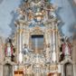 Zdjęcie nr 1: Nastawa ołtarzowa architektoniczna, jednoosiowa, jednokondygnacyjna ze zwieńczeniem, z bramkami i z rocaille'owymi uszami. Tabernakulum w formie zbliżonej do prostopadłościennej skrzynki, na wklęsło-wypukłym rzucie, ustawione na niskim cokole, o wypukłej ściance frontowej. Ujęte jest drewnianą obudową o wklęsłych bokach, flankowane parą ustawionych pod kątem pilastrów, których trzony przyjmują formę wolut. Zwieńczenie tabernakulum w formie niewielkiego szczytu, na którym ustawiona jest pasyjka. Całość ujęta po bokach rocaille'owymi wolutami. Drzwiczki w kształcie stojącego prostokąta, zamknięte łukiem nadwieszonym. W polu, na niebieskim tle malowane przedstawienie kielicha z hostią. Nastawa ustawiona na zdwojonym cokole, o  wklęsłym przebiegu, ujęta dwiema parami kolumn na tle zwielokrotnionych pilastrów. Podpory dźwigają pełne belkowanie, wyłamane pośrodku. Pomiędzy podporami figury: po lewej św. Józefa, a po prawej św. Jana Chrzciciela, nad bramkami: po lewej św. Wojciecha, a po prawej św. Stanisława. Nad tabernakulum rocaille'owy kartusz z łacińską inskrypcją w polu. W polu środkowym nisza w formie stojącego prostokąta, zamkniętego łukiem wklęsło-wypukłym z uskokami z obrazem „Święta Rozmowa”. Zwieńczenie w formie zbliżonej do stojącego prostokąta ujętego po bokach dwoma pilastrami, bogato ozdobione dekoracją rzeźbiarską. W polu przedstawienie Trójcy Świętej, flankowane przez parę aniołów siedzących na wolutowych przyczółkach. Całość zamyka para aniołków ze srebrną wstęgą z napisem „GLORIA IN EXCELSIS DEO”. Bramki z drzwiczkami w formie stojącego prostokąta, flankowane węgarami, zamknięte wolutowym łukiem z zatkniętymi na szczycie rzeźbami świętych. Drzwiczki dekorowane w polu dwiema płycinami. Całość nastawy silnie dekorowana ornamentyką rokokową. Kolumny ustawione na bazach, z kompozytowymi kapitelami, wewnętrzne srebrzone, do jednej trzeciej wysokości zdobione kanelowaniem zamkniętym pierścieniem, kolumny zewnętrzne marmoryzowane. Struktura polichromowana w kolorze beżowym, profilowania marmoryzowane, ornamentyka złocona.